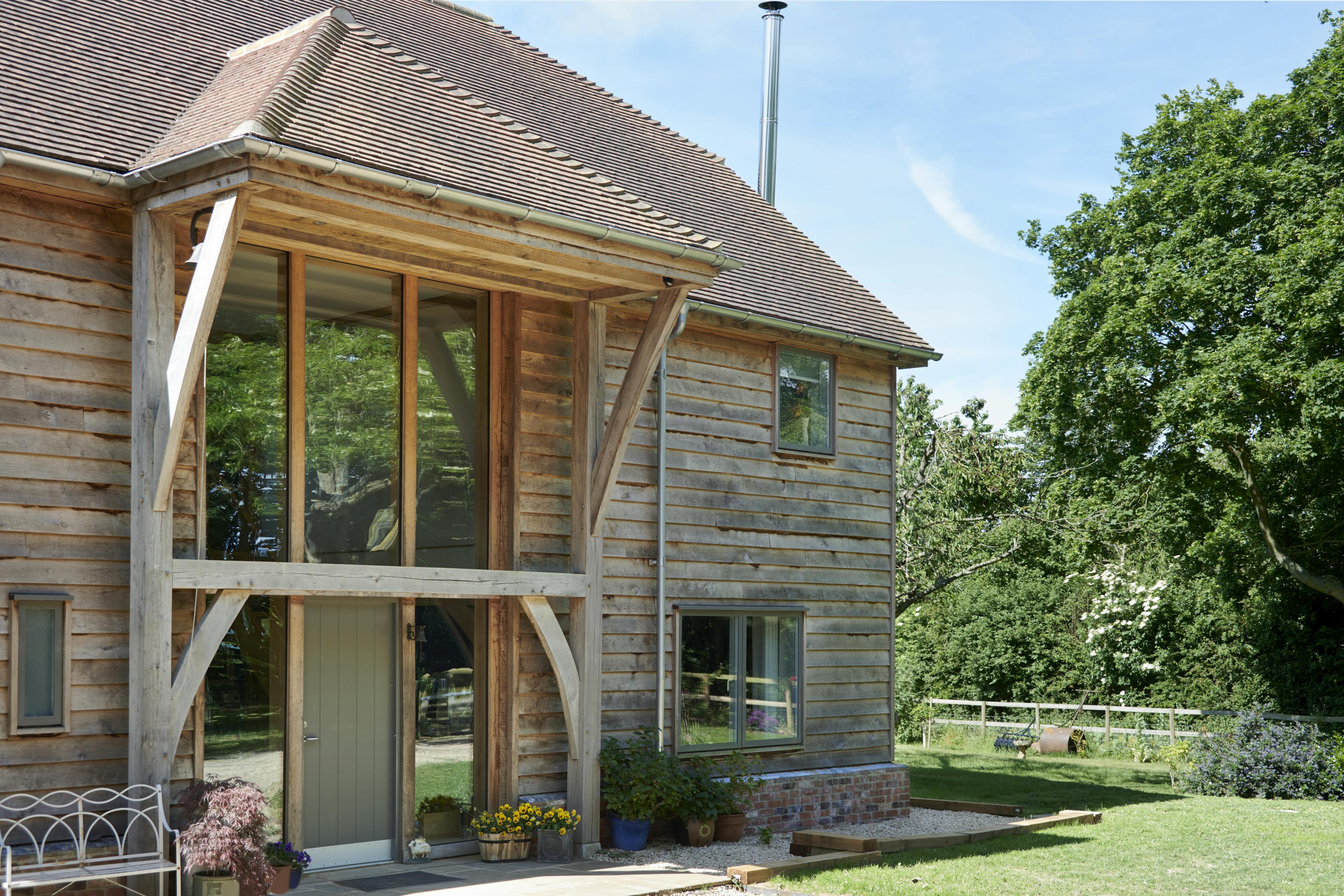 Green front door on an oak framed home with timber cladding