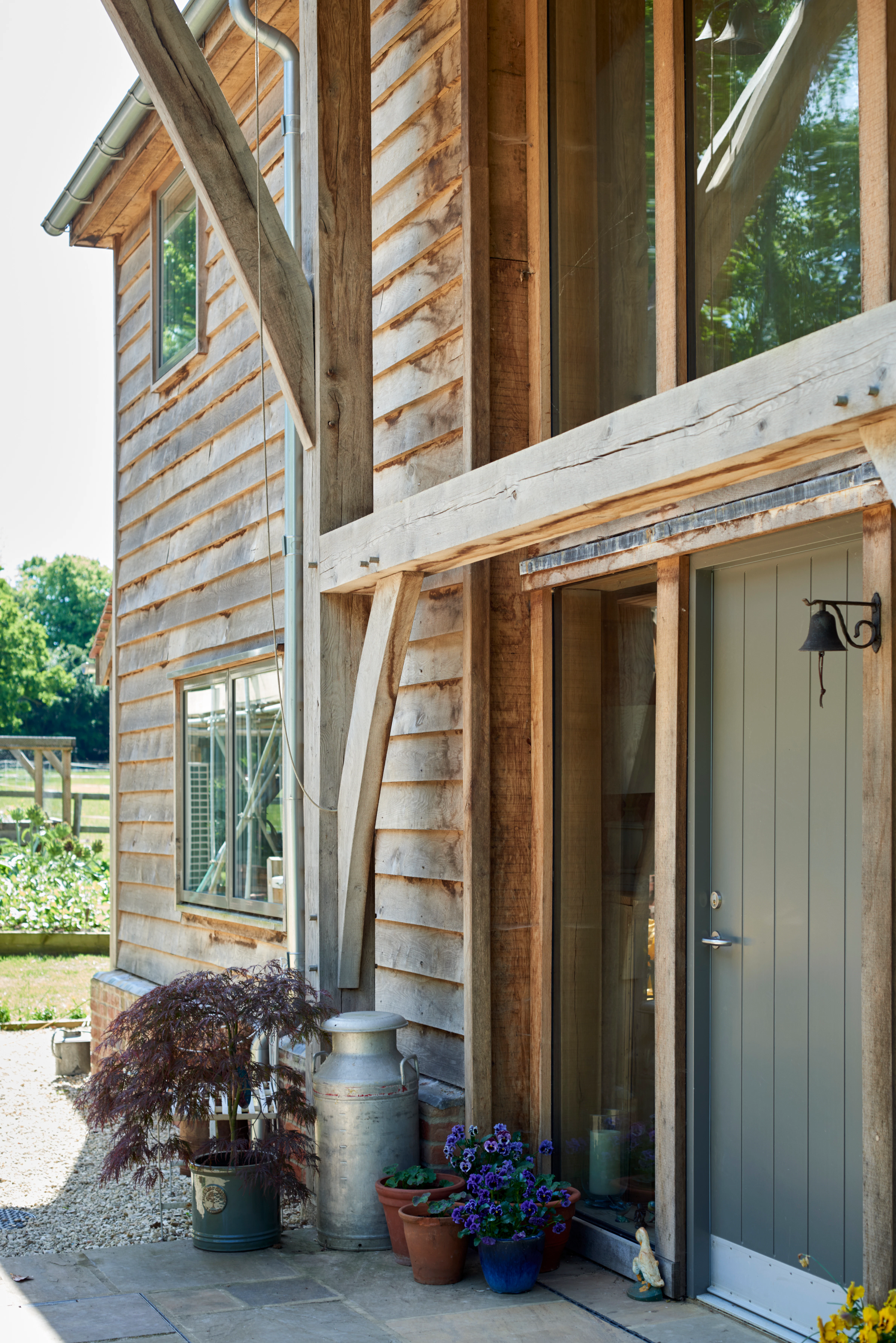 Green front door on an oak framed home with timber cladding