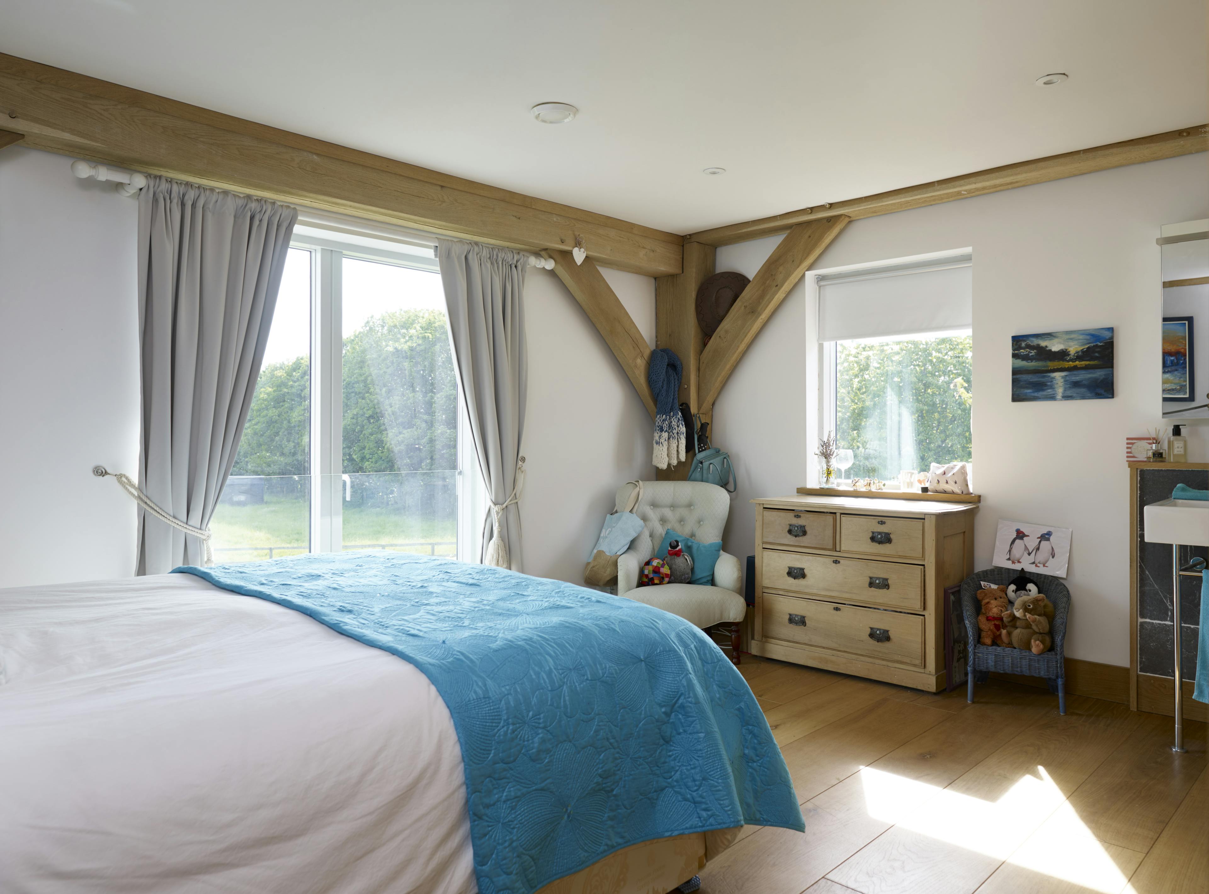 An oak framed bedroom with sliding doors to a garden