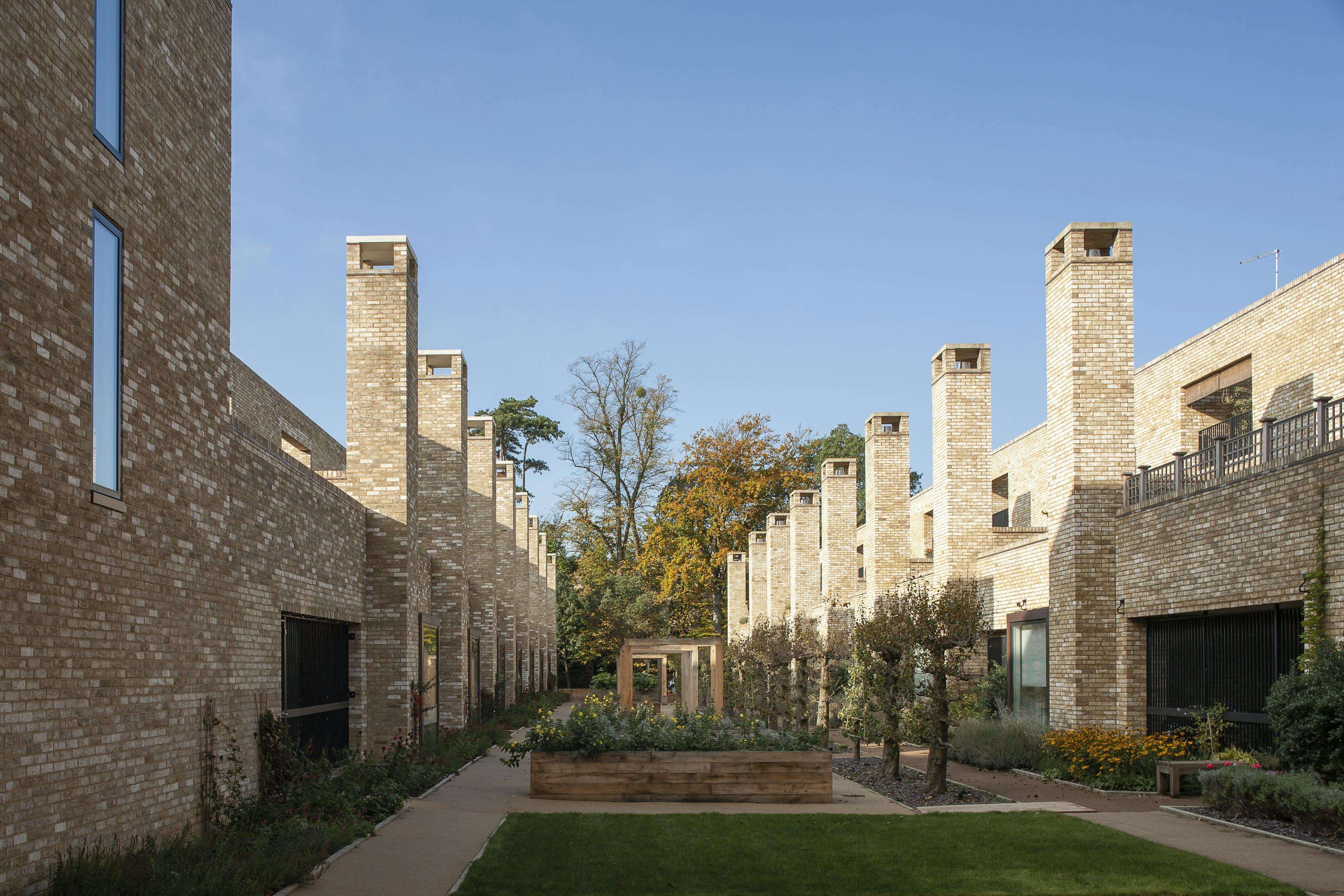 Exterior view of modern houses and apartments featuring oak-framed courtyards, roof terraces, and spacious balconies