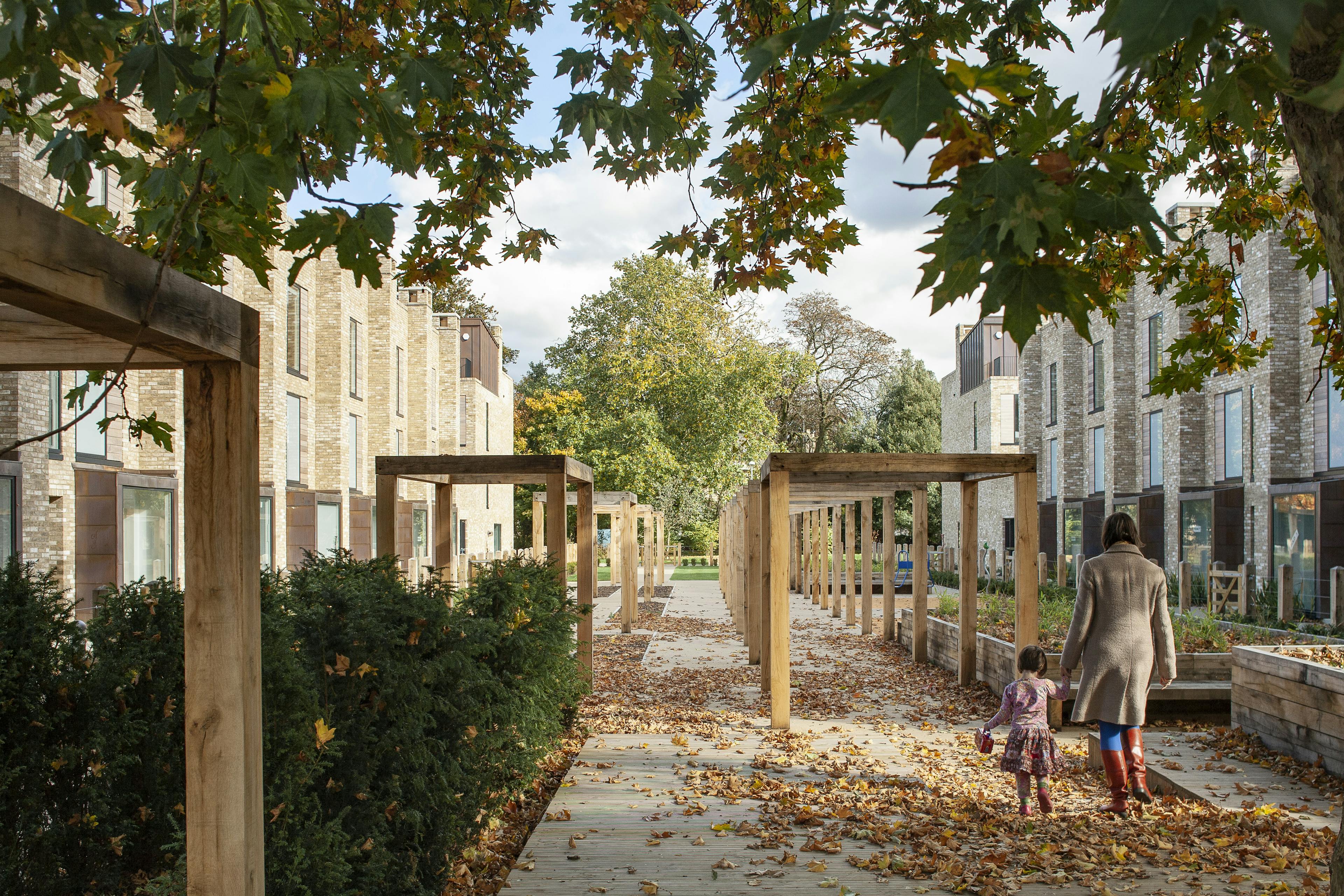 Exterior view of contemporary houses and apartments encircling communal gardens