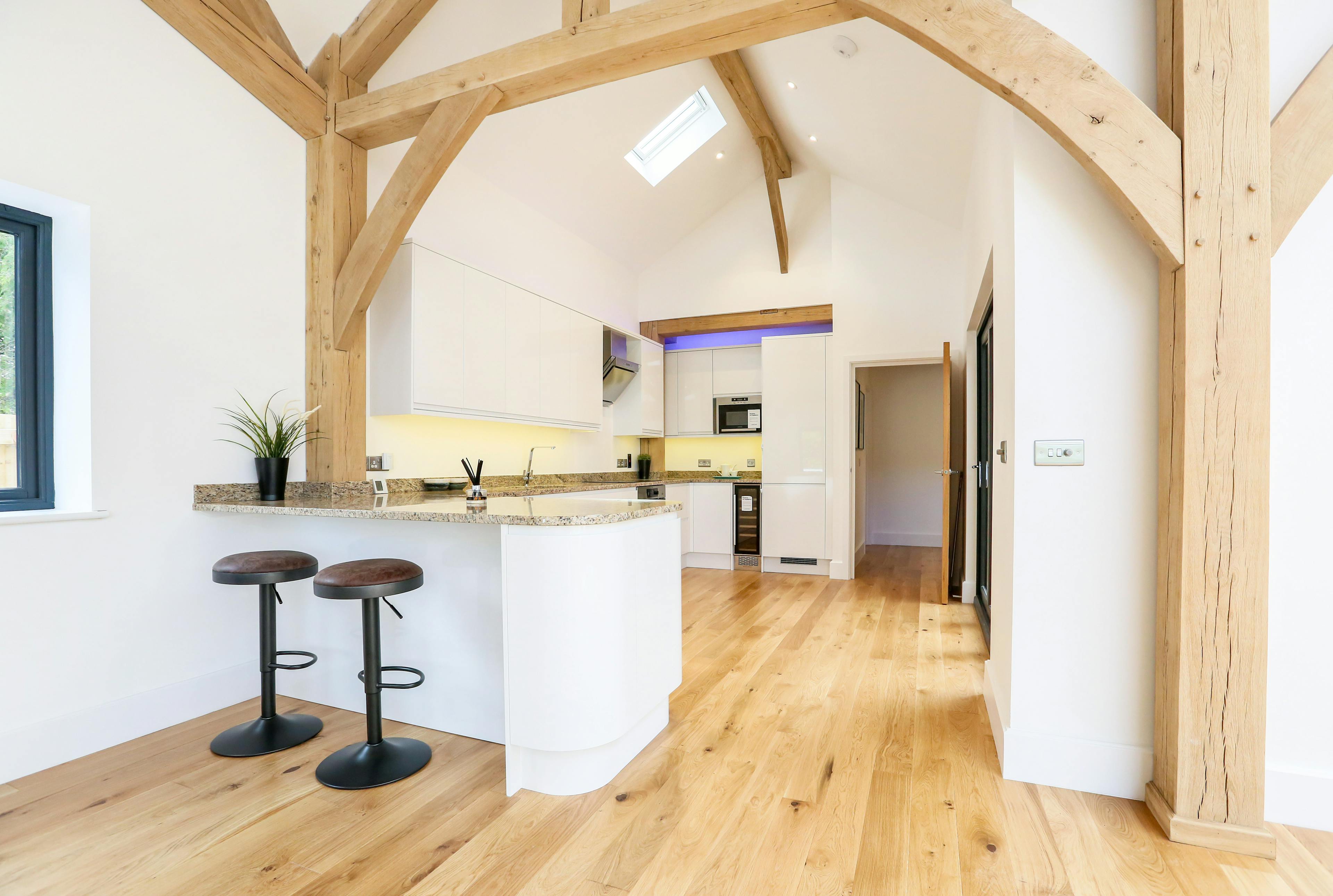 A light filled modern oak frame home showing the kitchen and breakfast bar