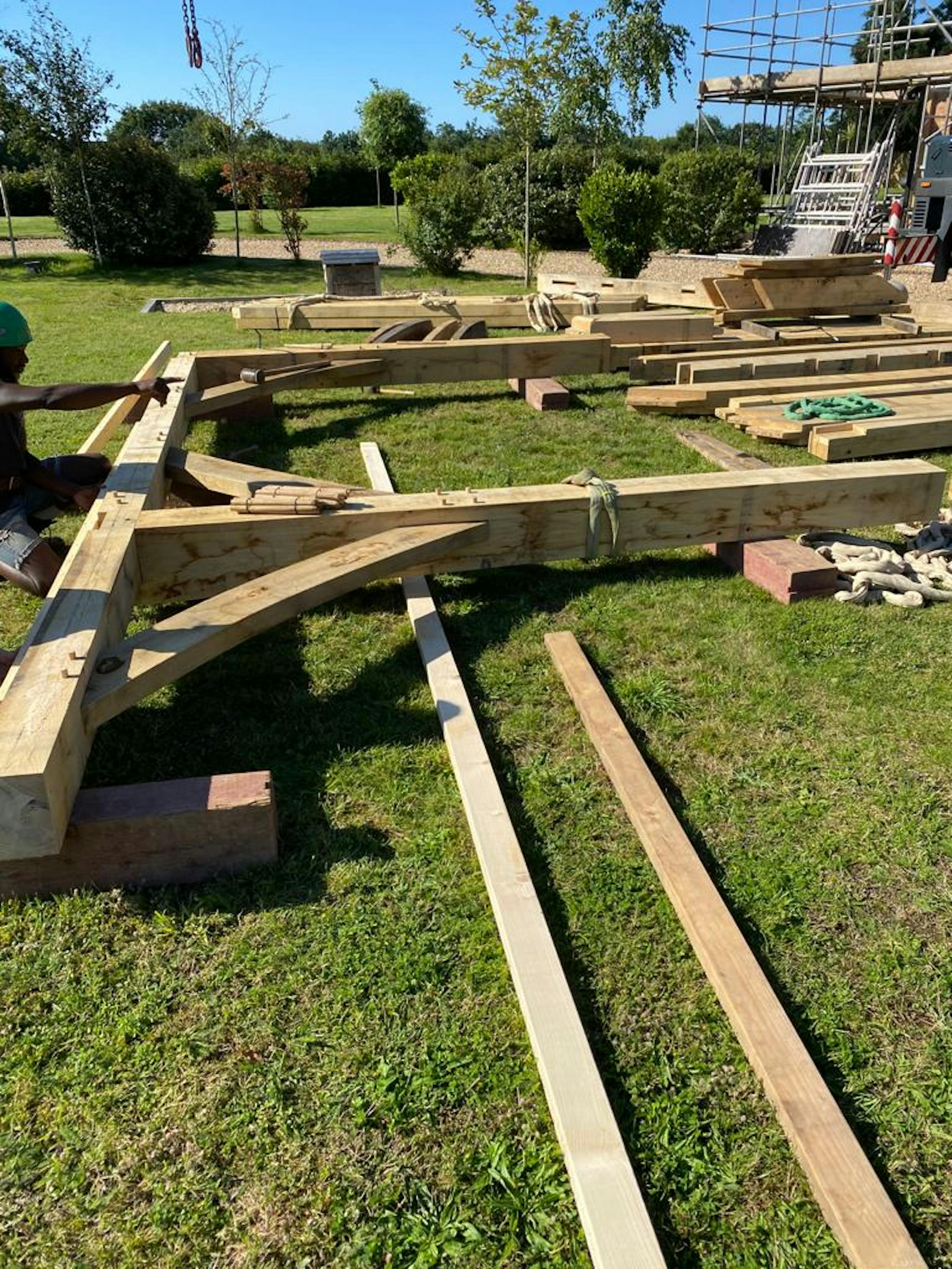 An oak frame is laid out on a green lawn