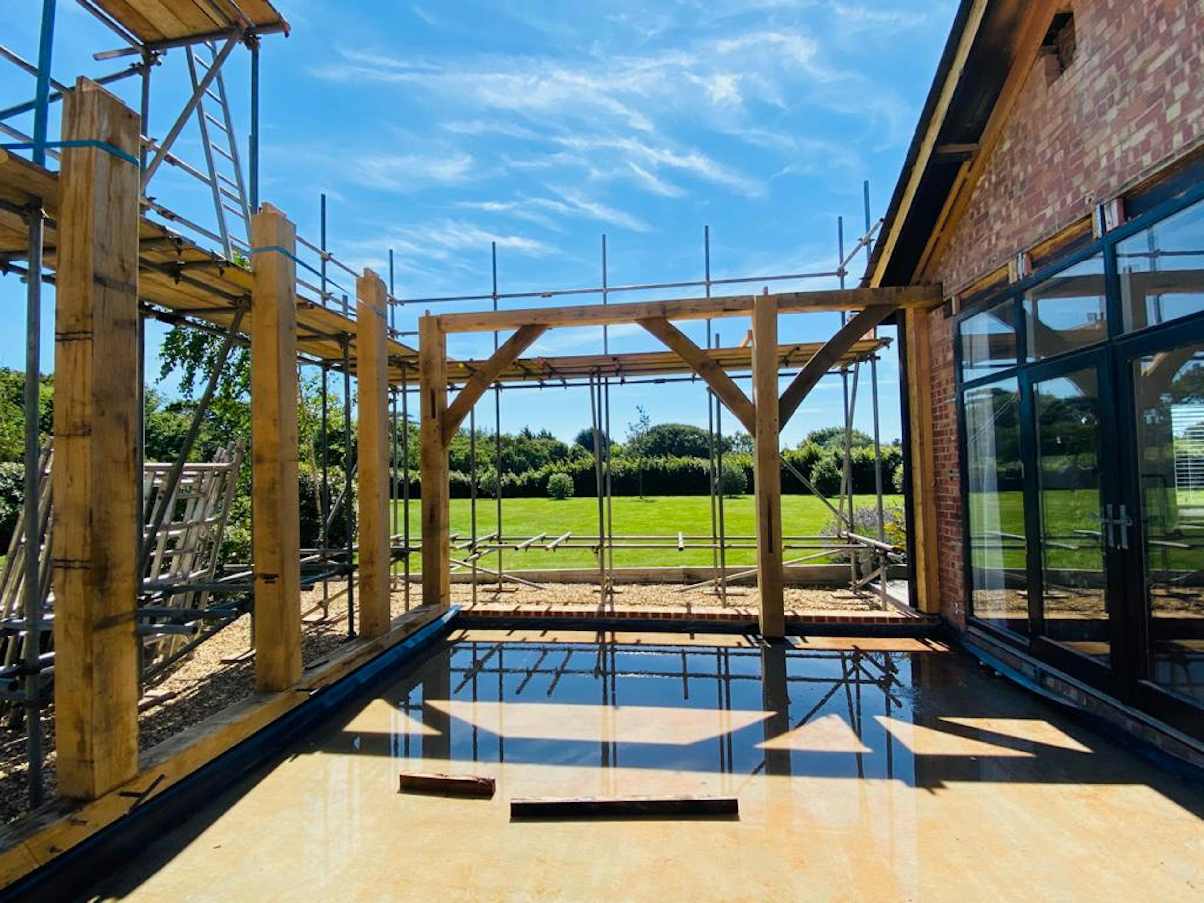 Under blue skies an oak framed extension is under construction