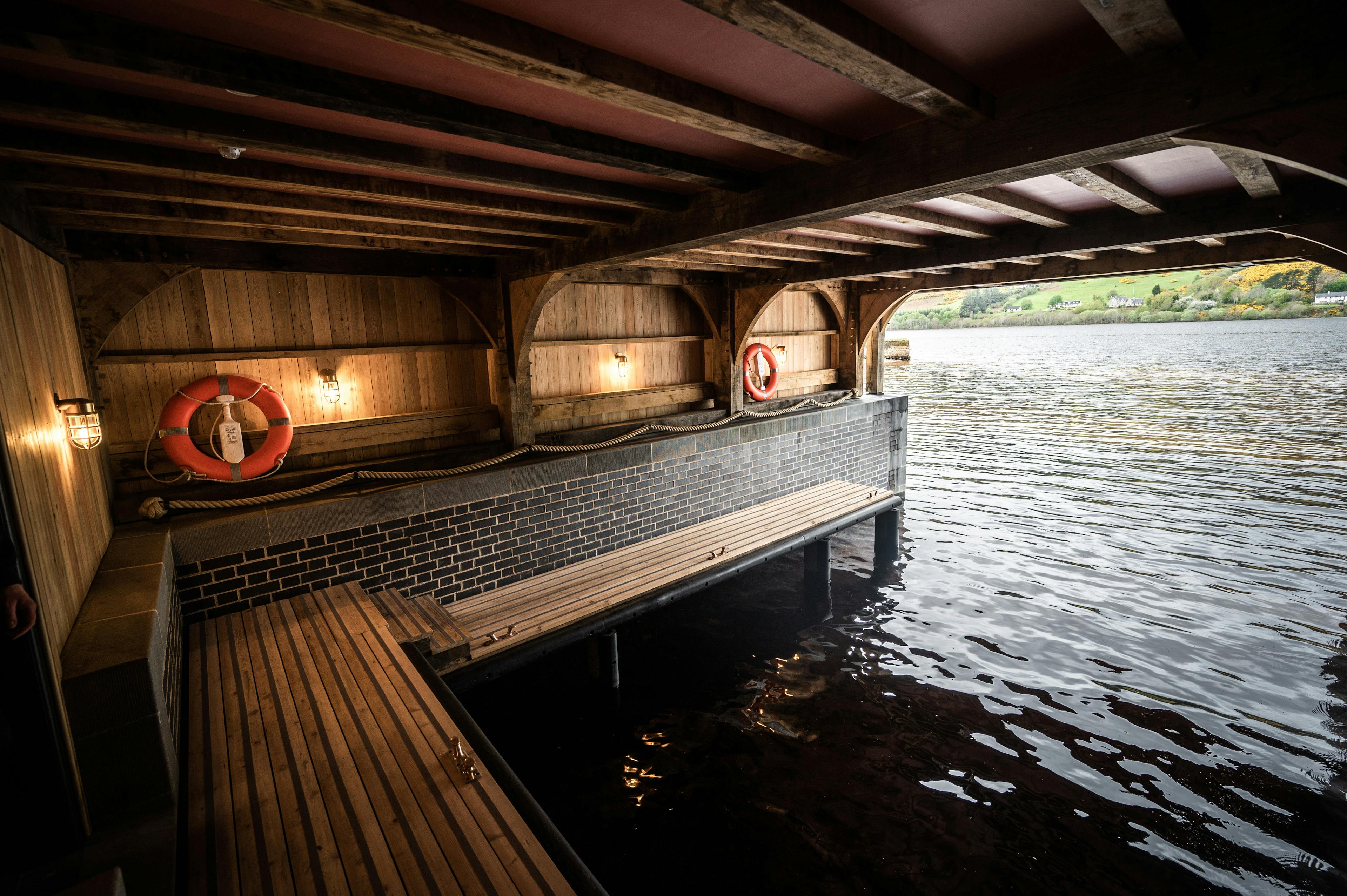 The boat storage underneath a timber framed boathouse on Loch Ness