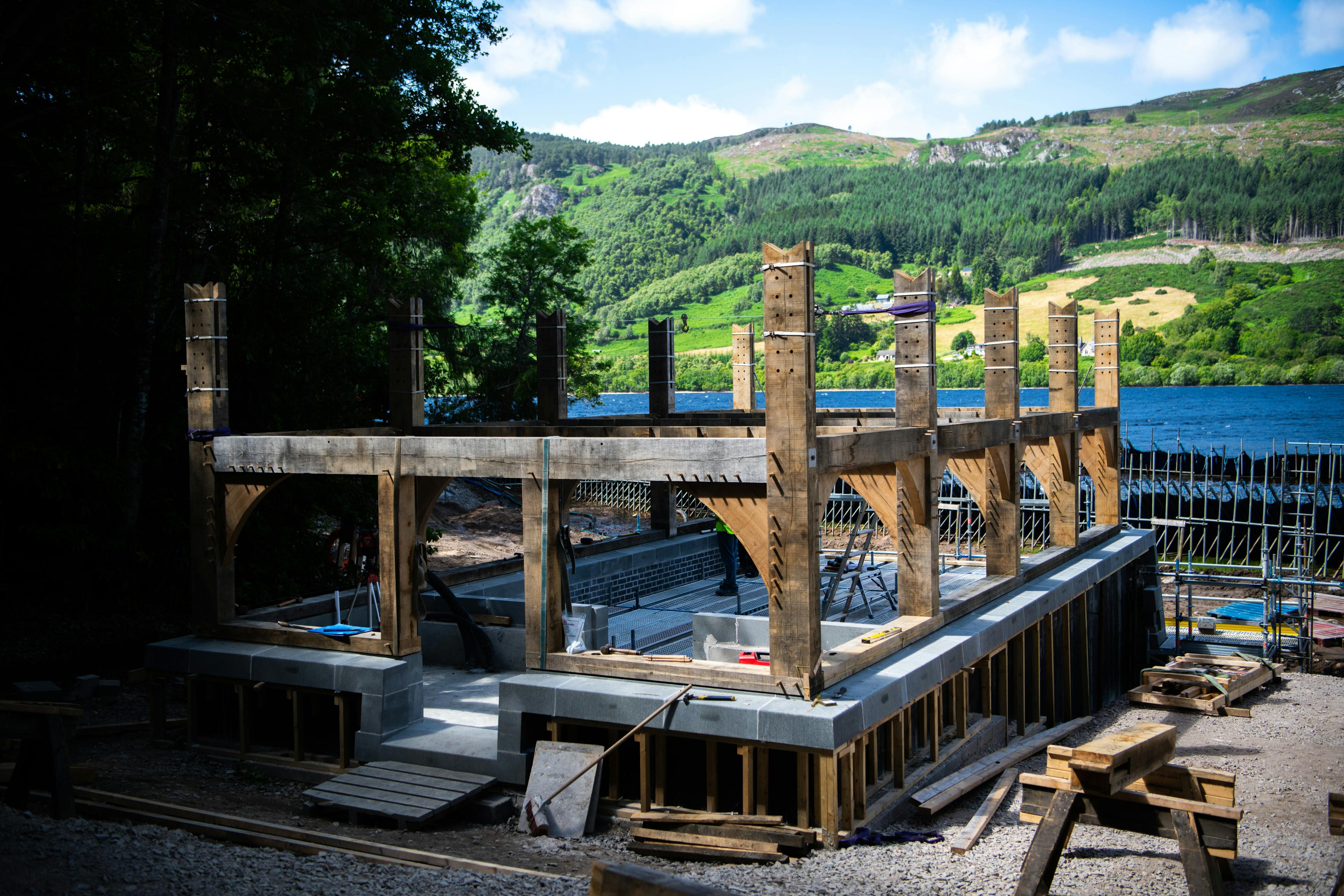 An oak framed boathouse by a lake during construction