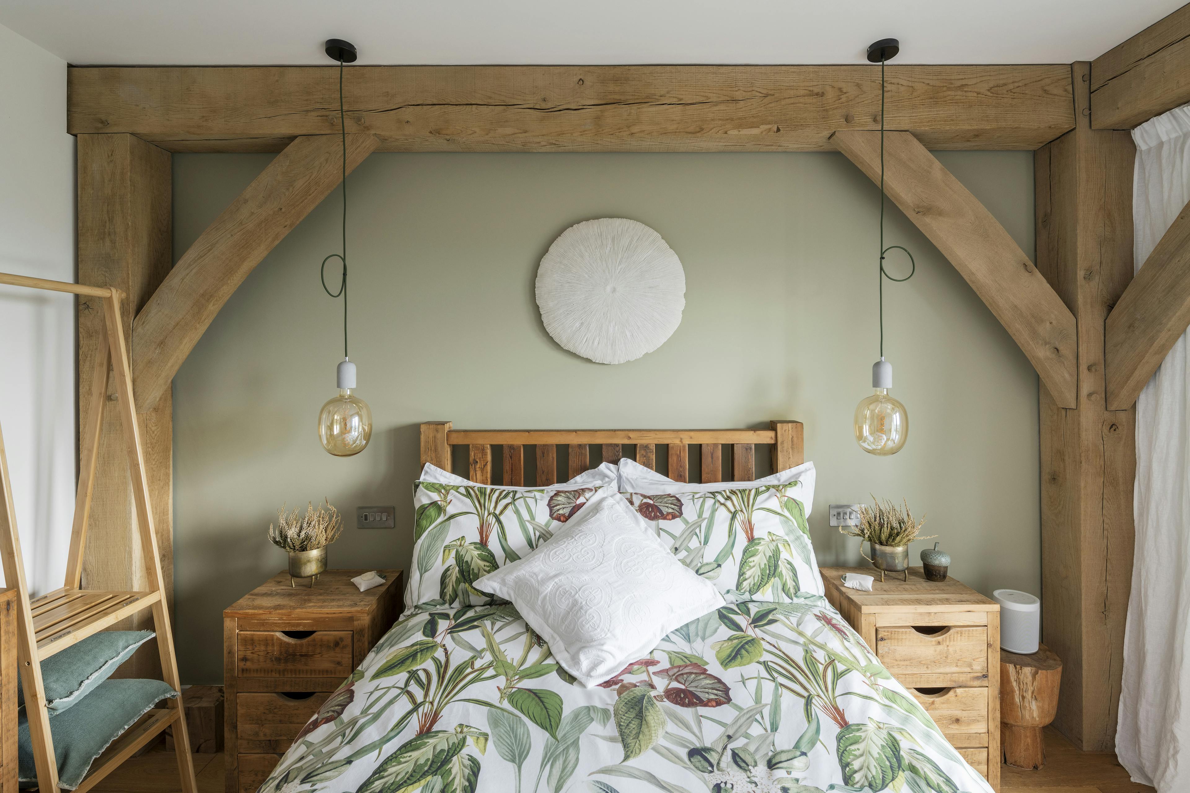 An oak framed bedroom with a double bed in the middle of the bay