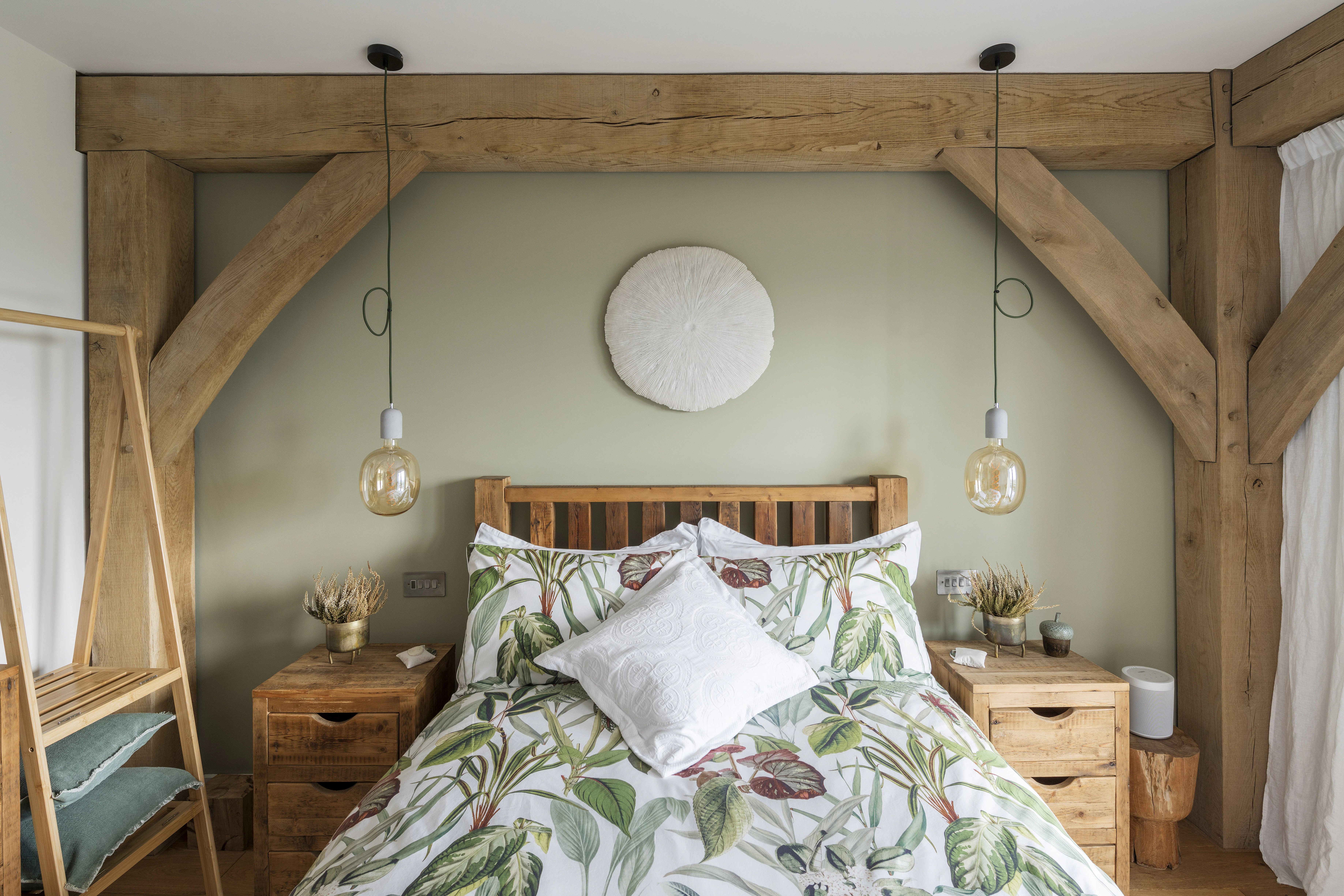 An oak framed bedroom with a double bed in the middle of the bay
