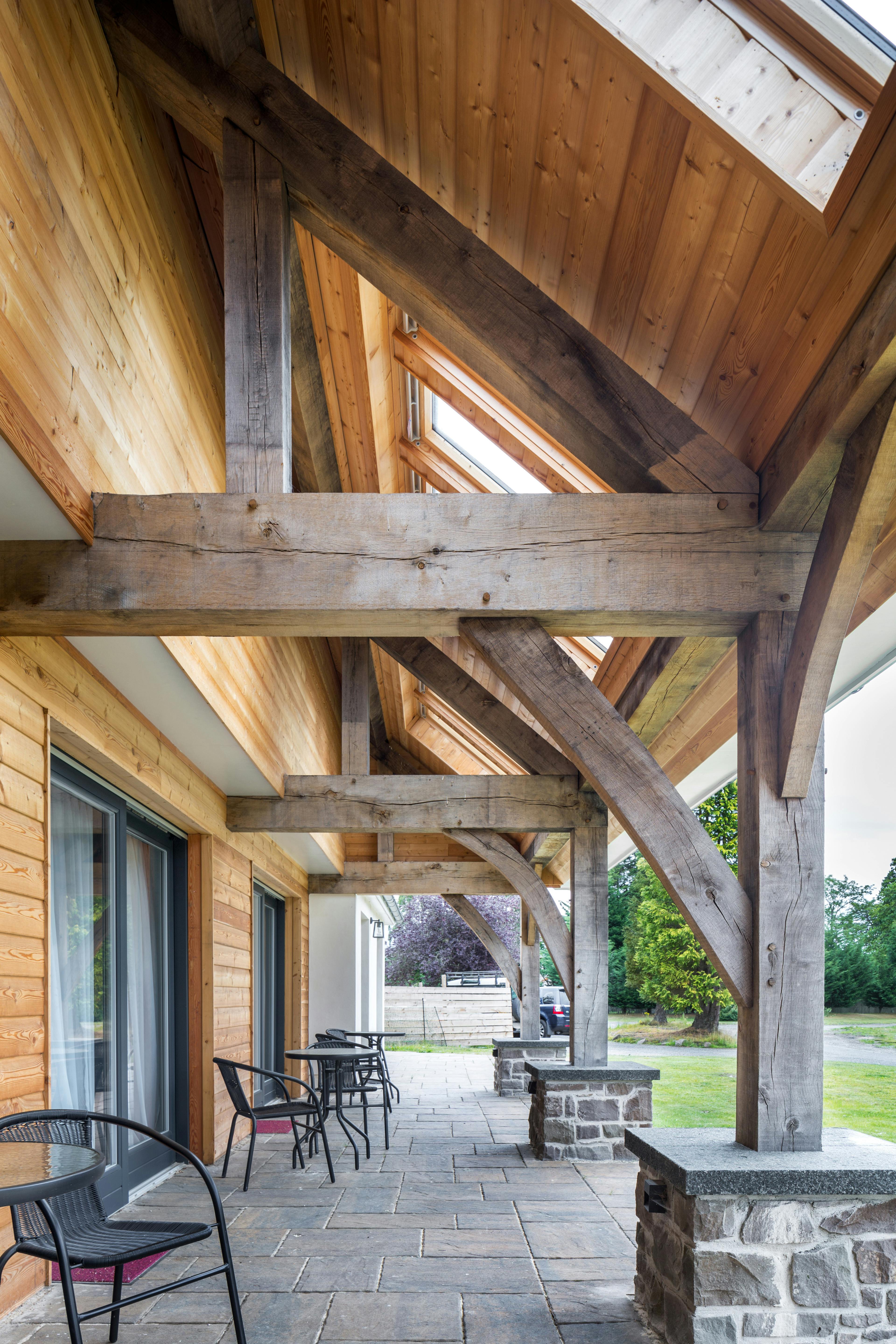 Underneath the eaves of a building which are held up with an oak frame to create a veranda