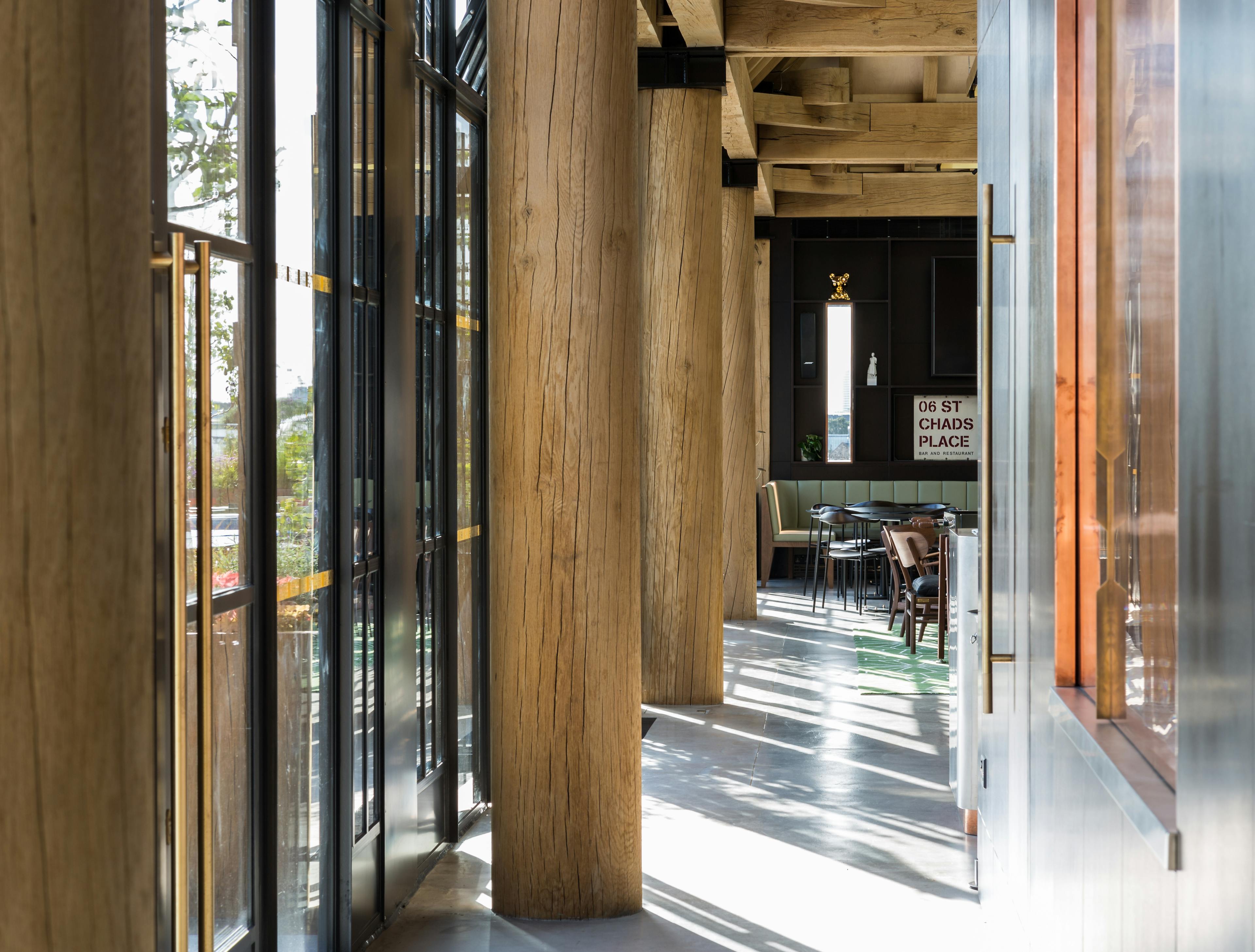 Turned oak posts in a corridor with sunshine coming through glazed windows