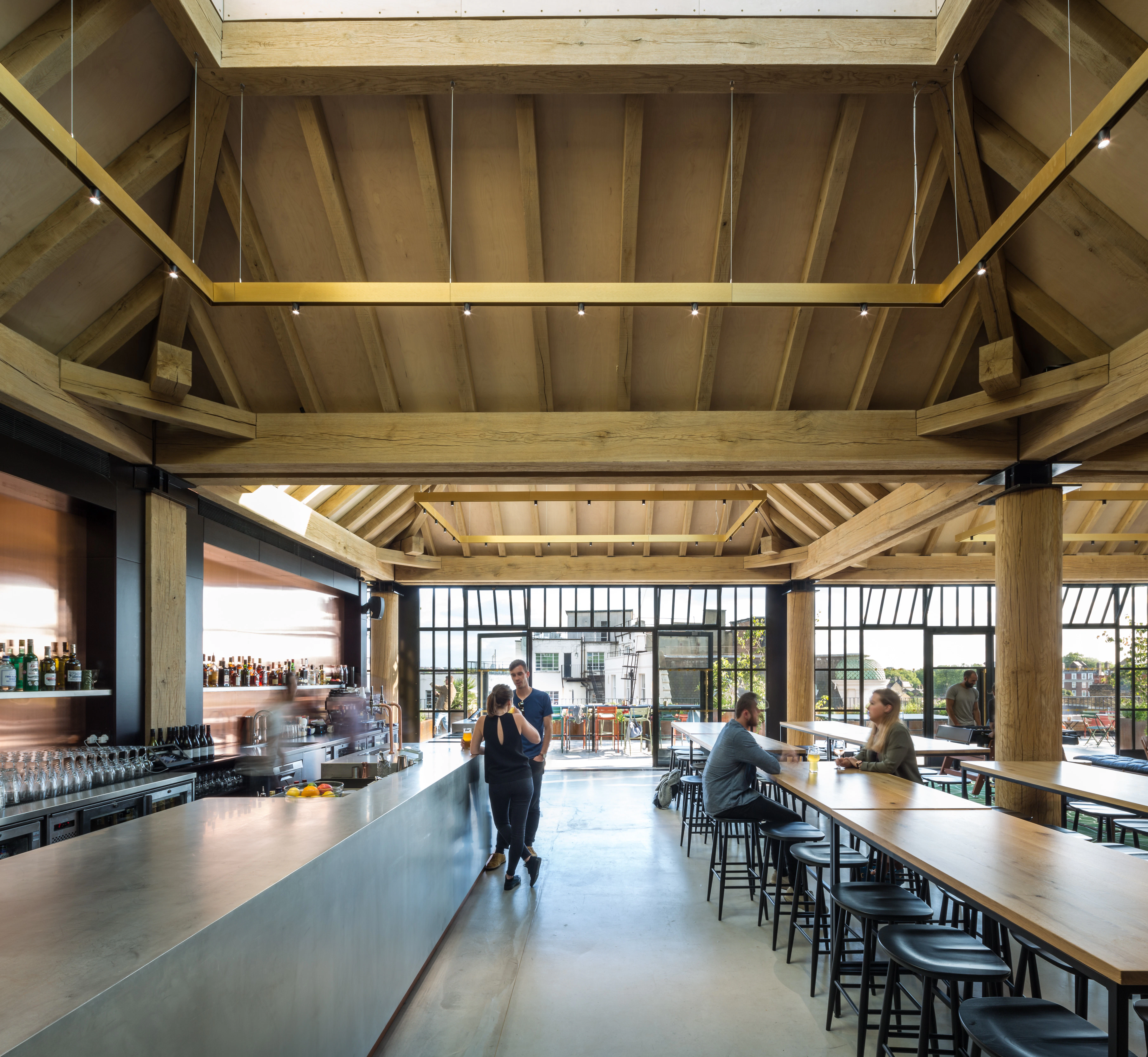 Oak frame lanterns link to create a rooftop bar with customers sat at tables