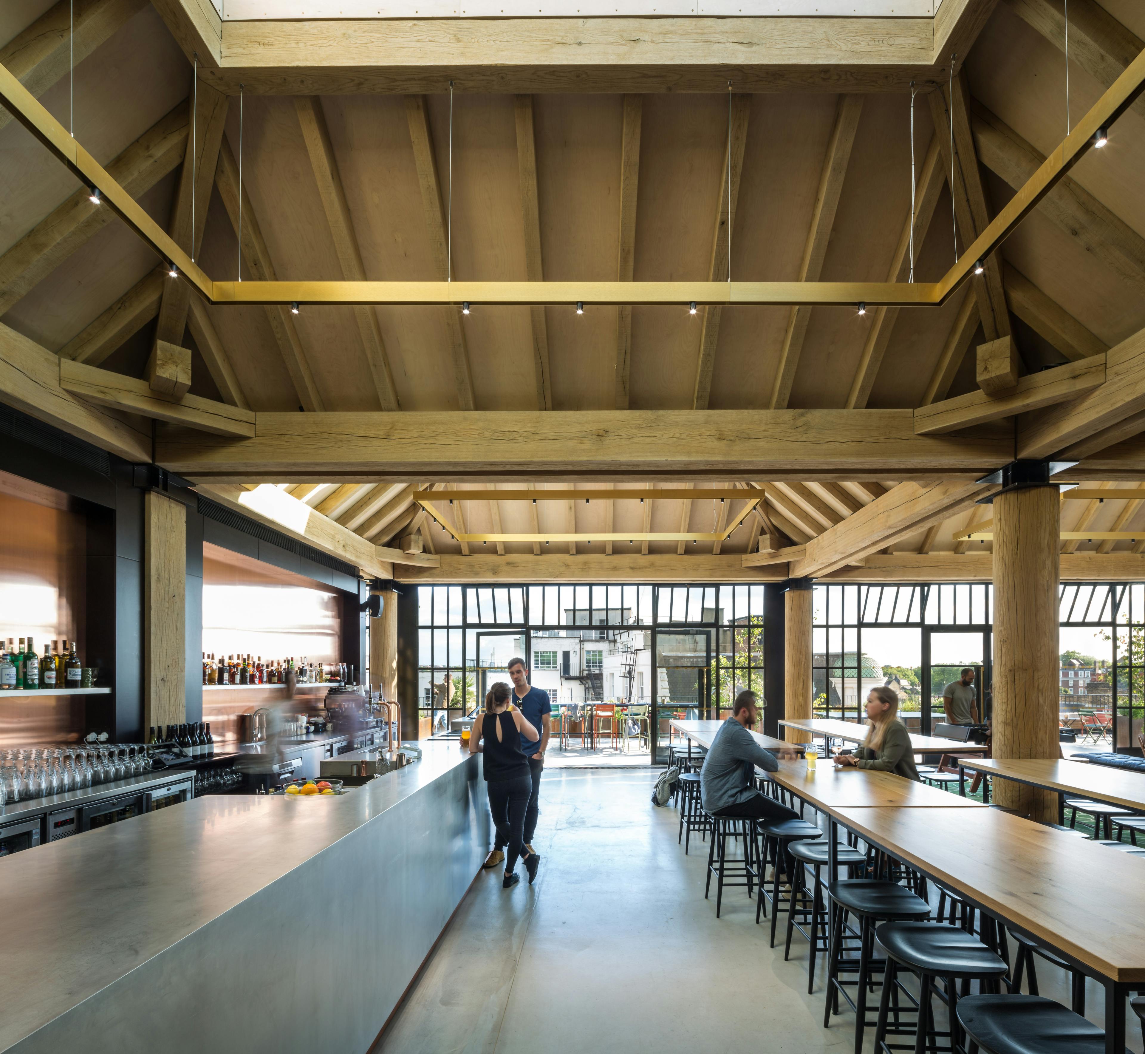 Oak frame lanterns link to create a rooftop bar with customers sat at tables