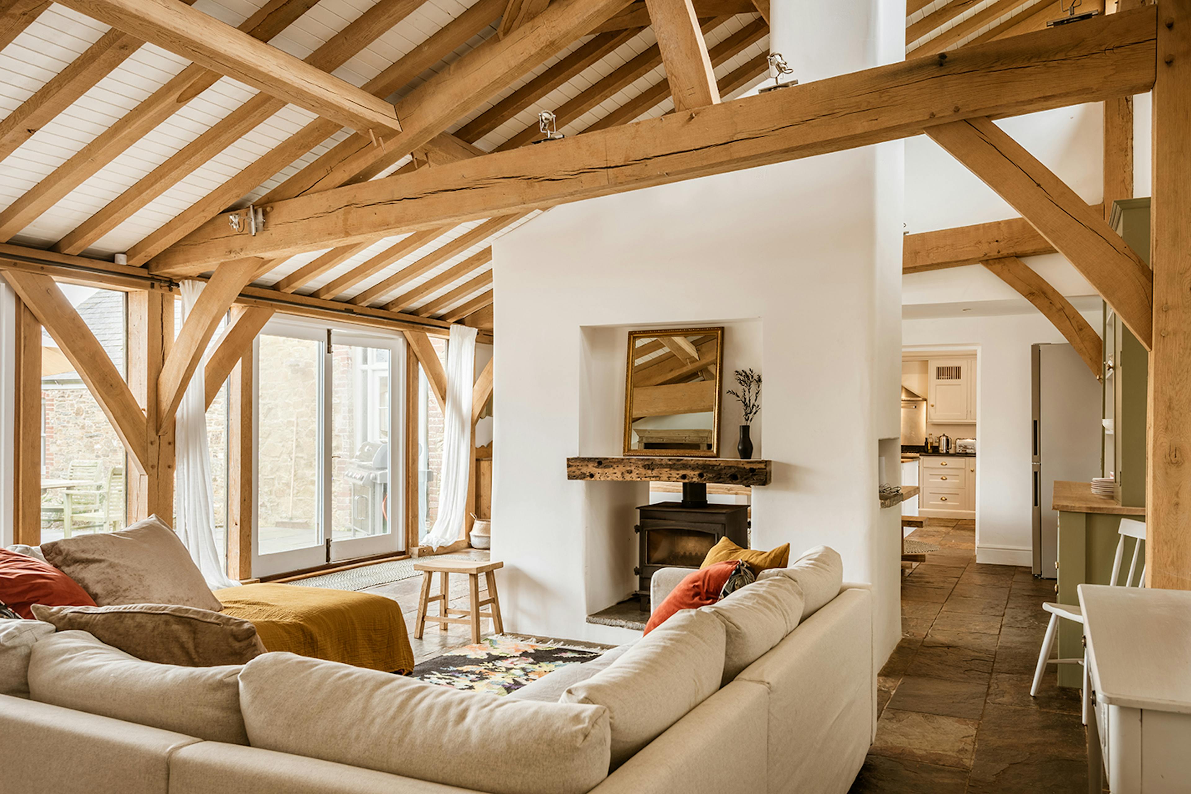 An oak framed extension with sitting area with sofas and a log burner