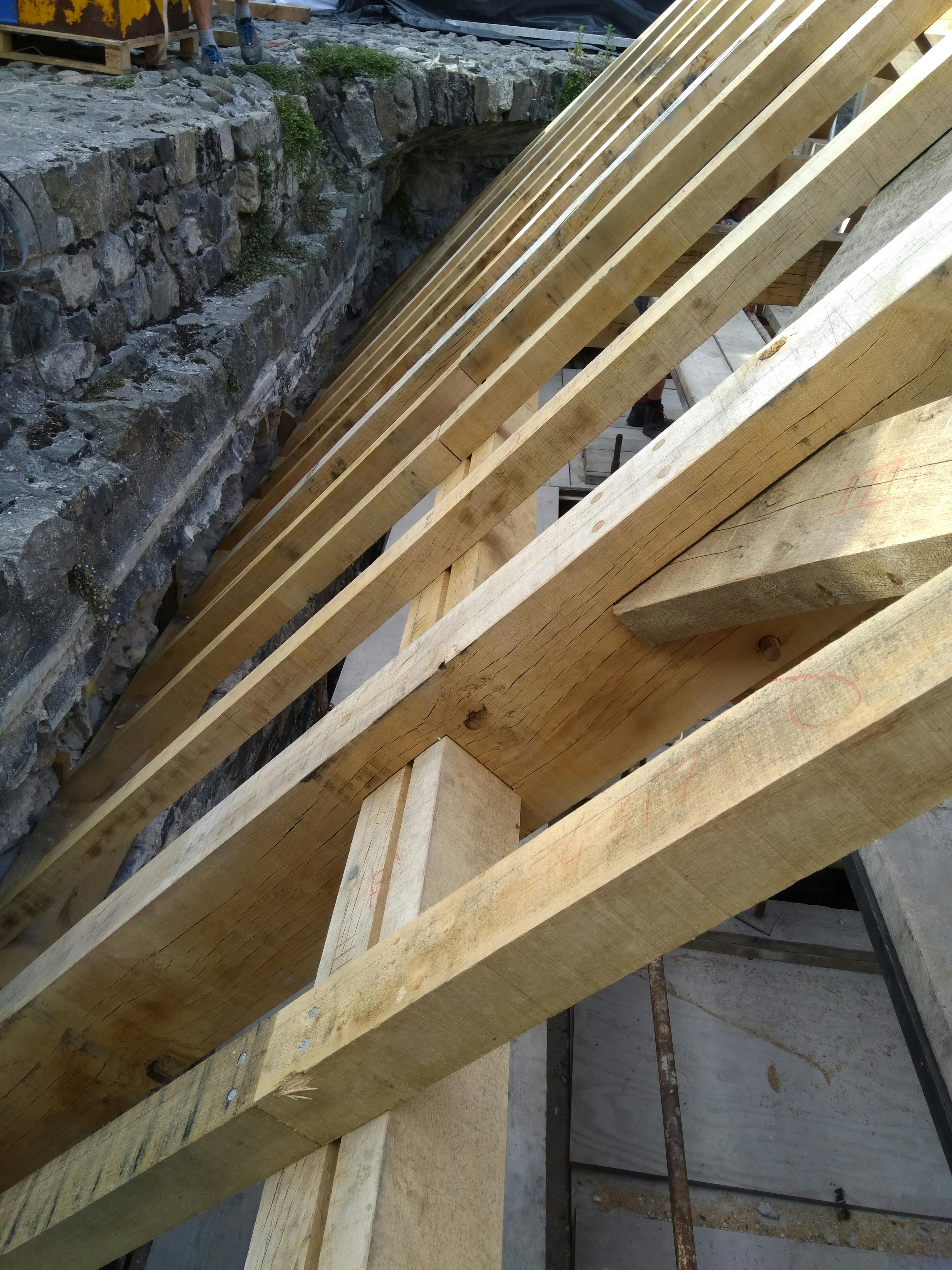 The detail of an oak frame installed into a stone tower of a castle