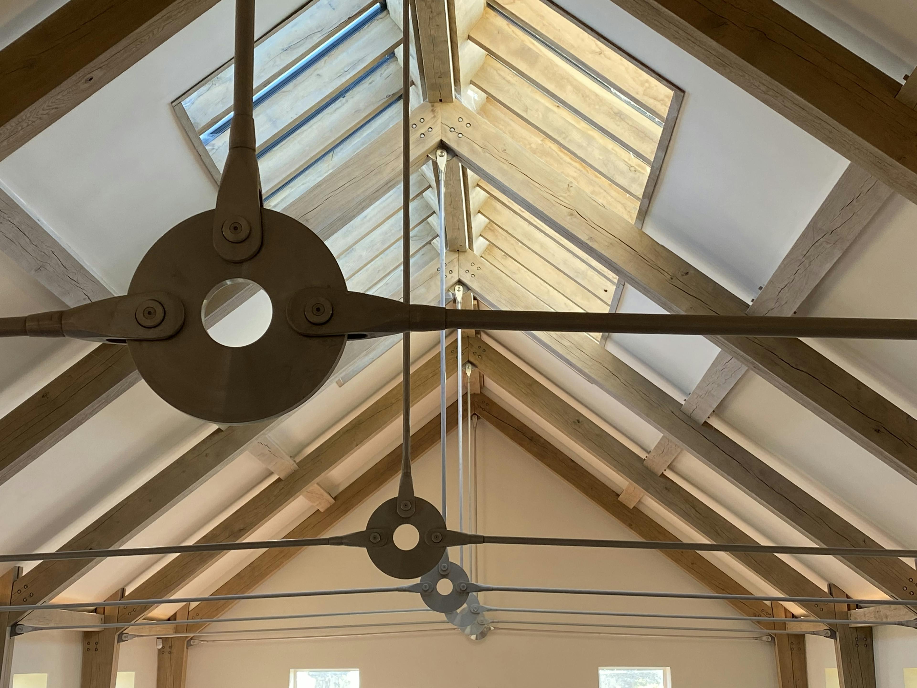 The ceiling of a swimming pool rooflights, showing an oak frame and steel tie connections