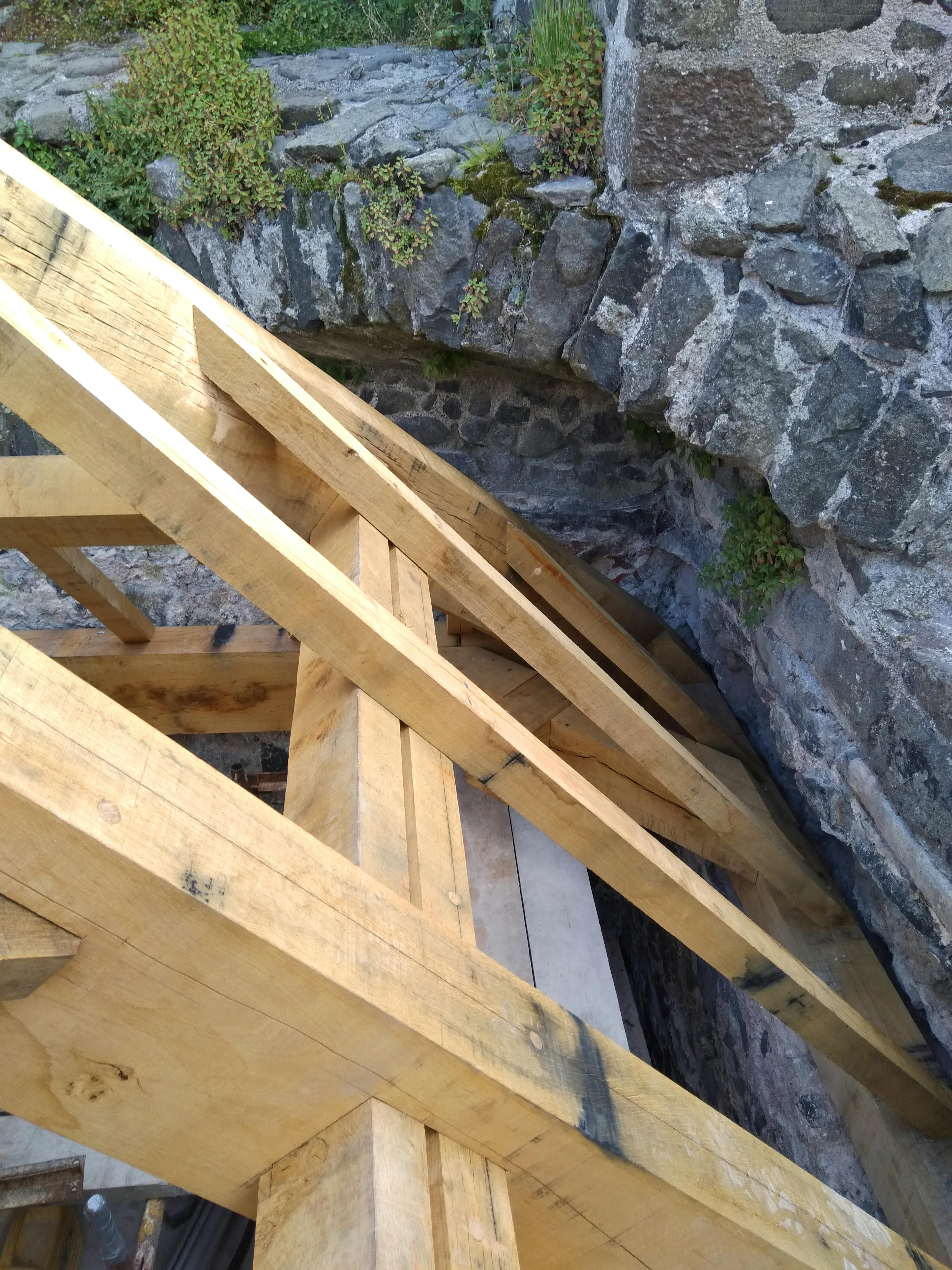 The detail of an oak frame installed into a stone tower of a castle
