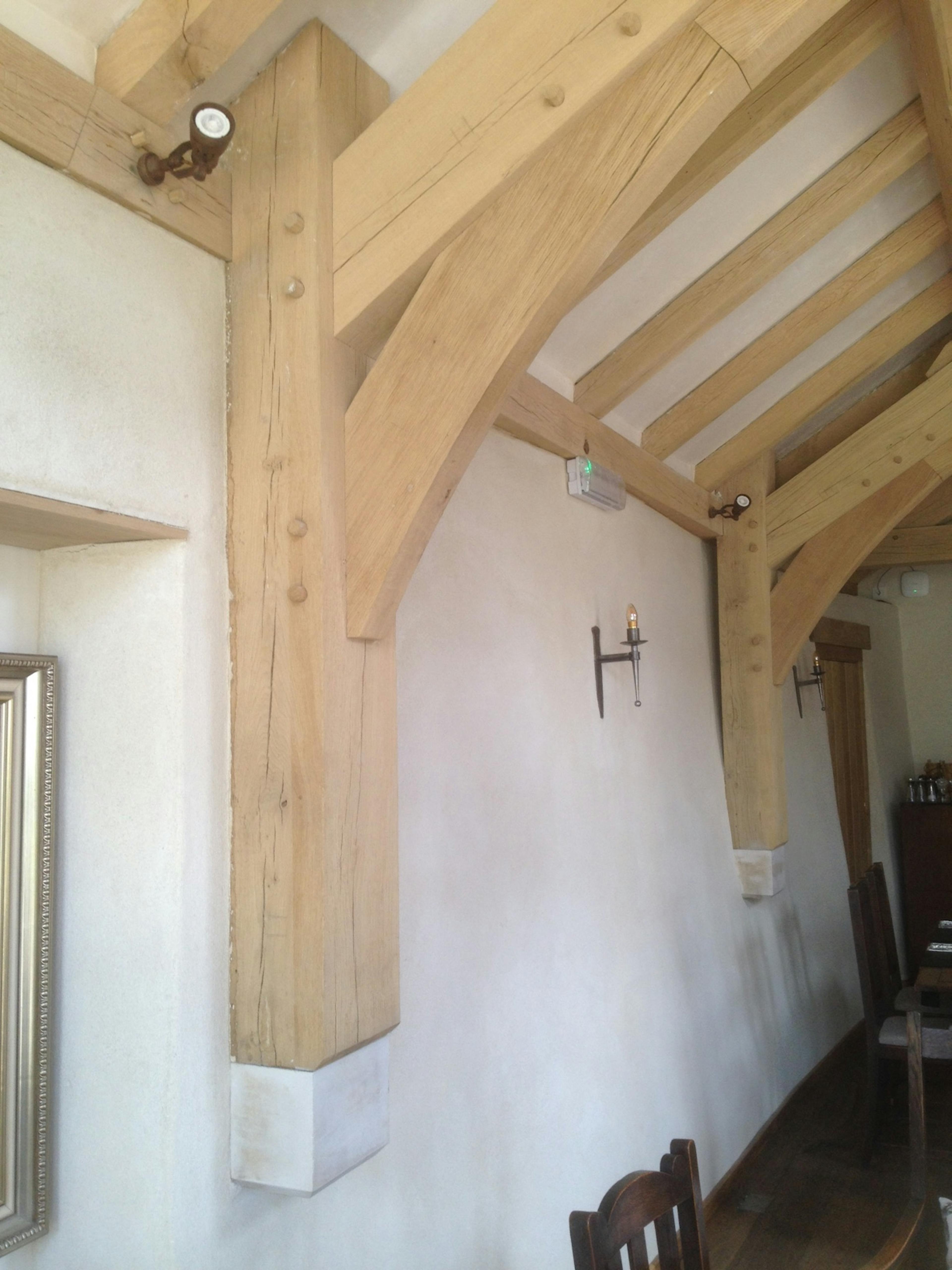 An oak frame post joins to a corbel in an oak framed room