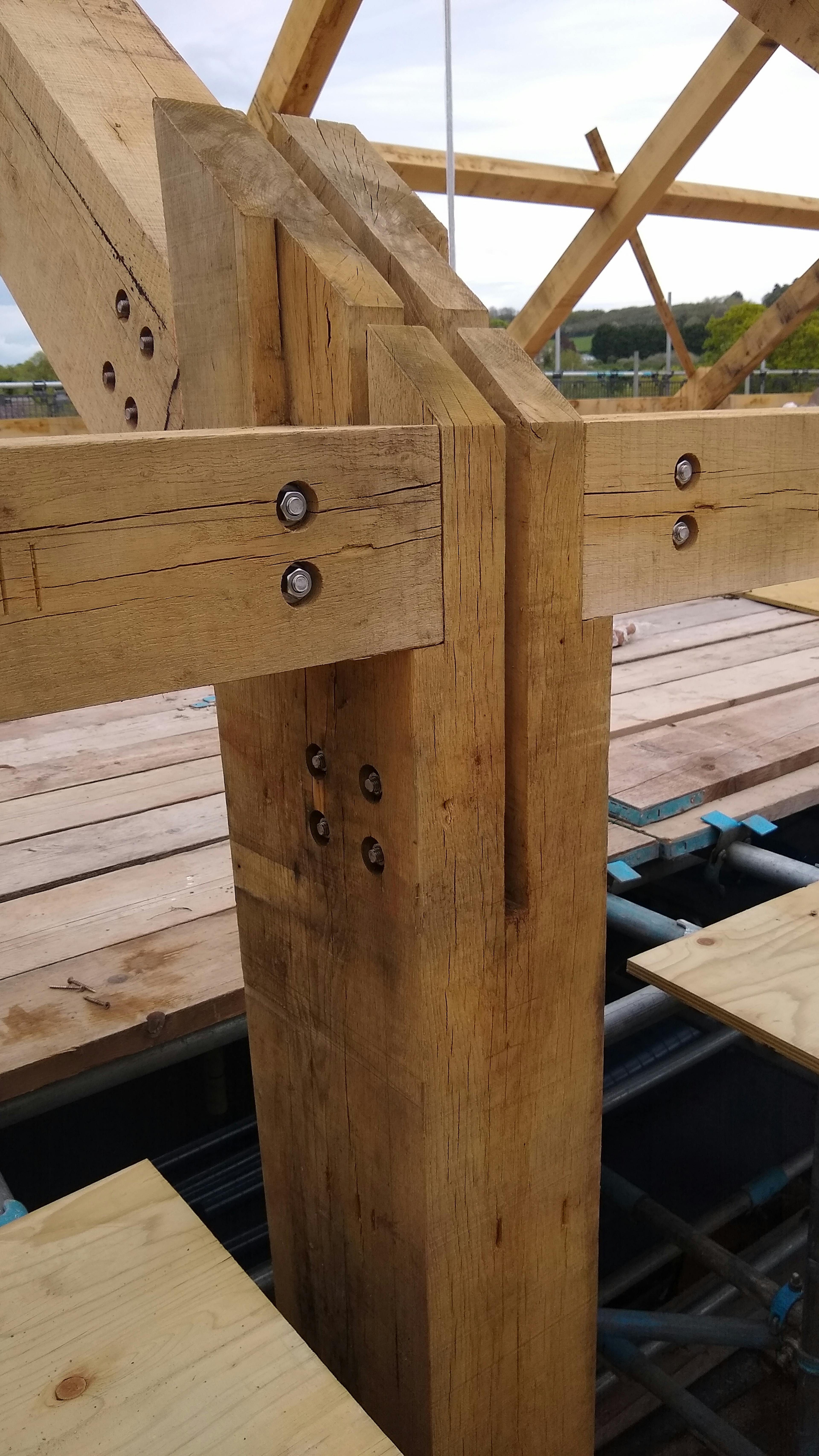 Close up image of part of an oak frame being installed on a construction site