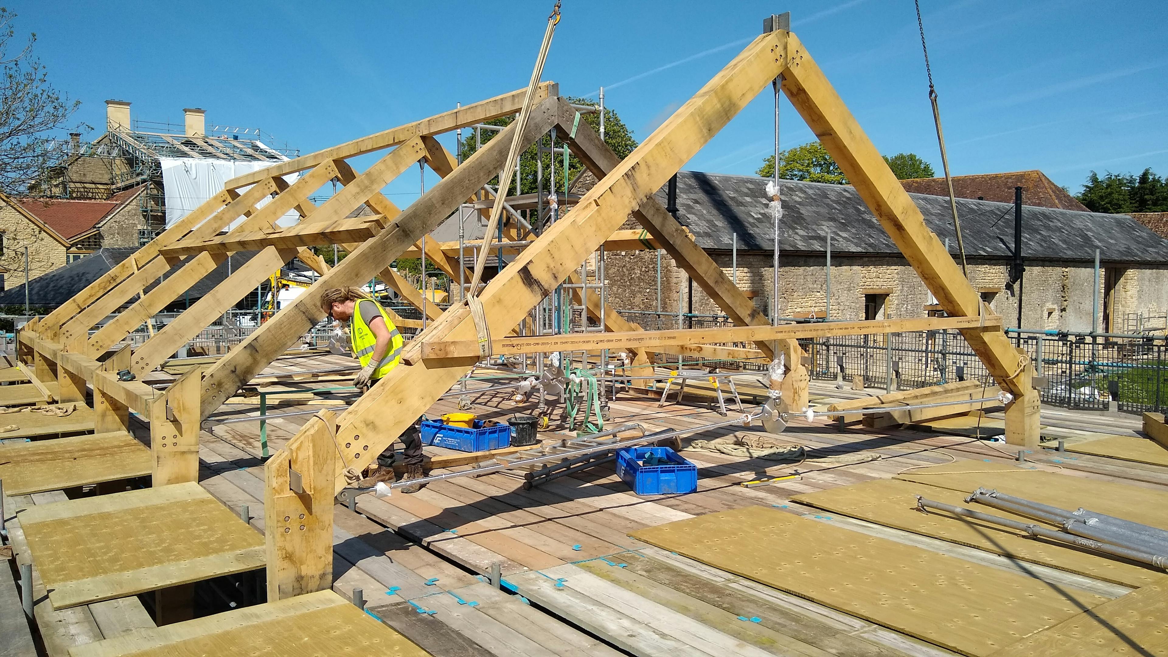 An oak frame roof being installed on a construction site