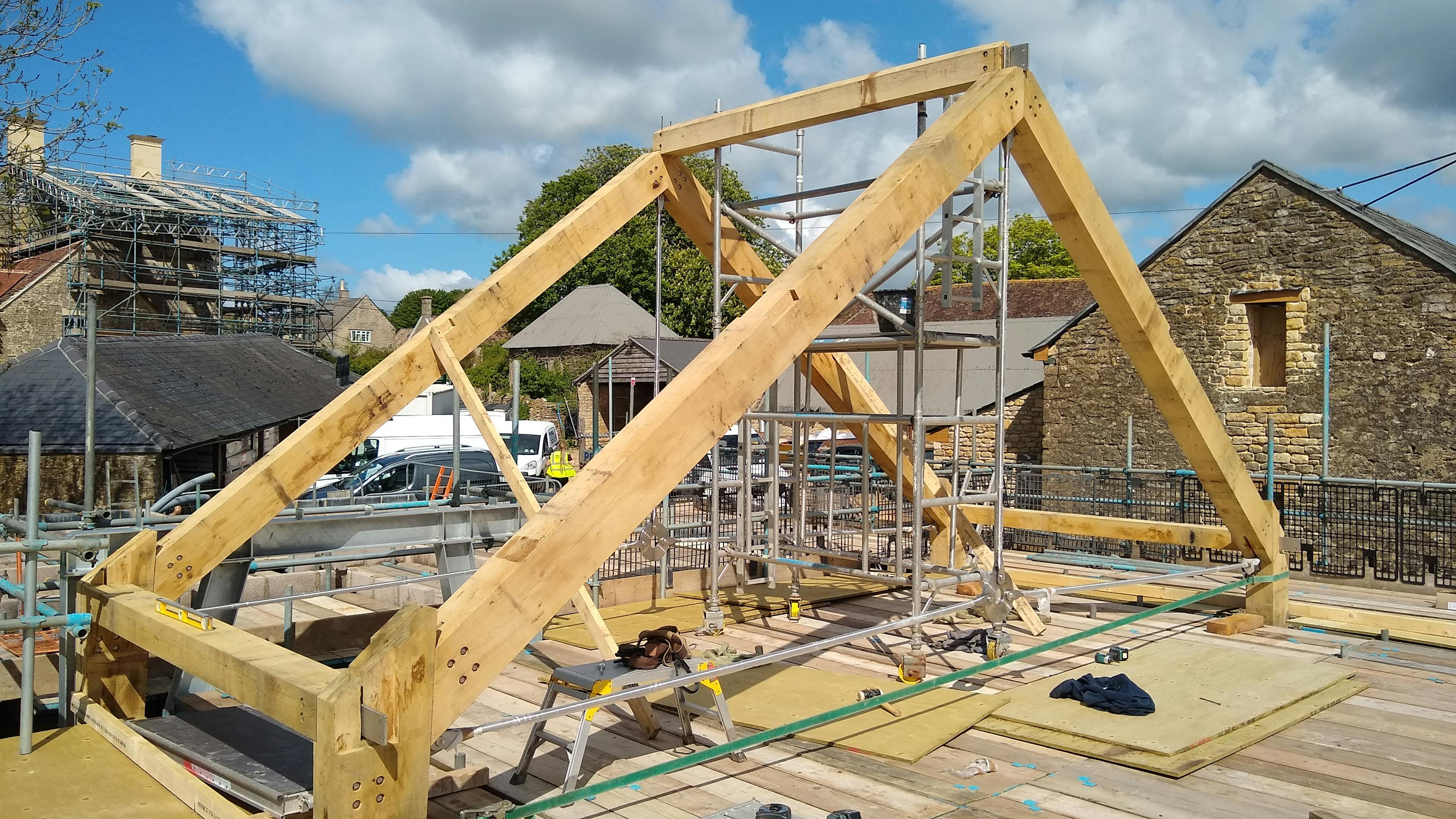 An oak frame roof being installed on a construction site