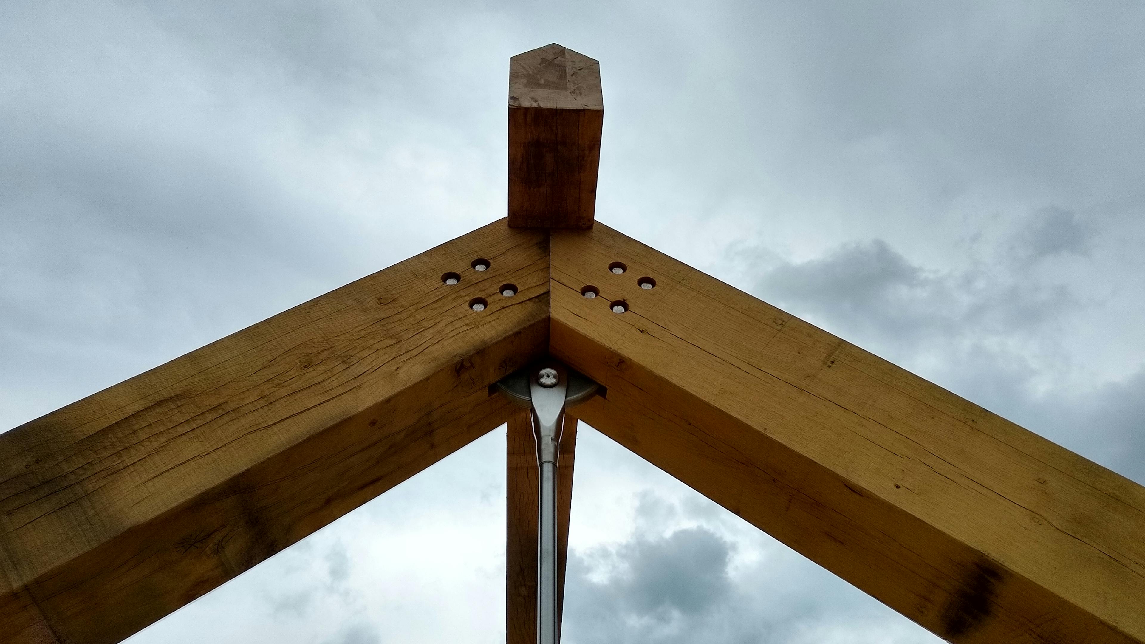 The truss of an oak frame roof being installed on a construction site