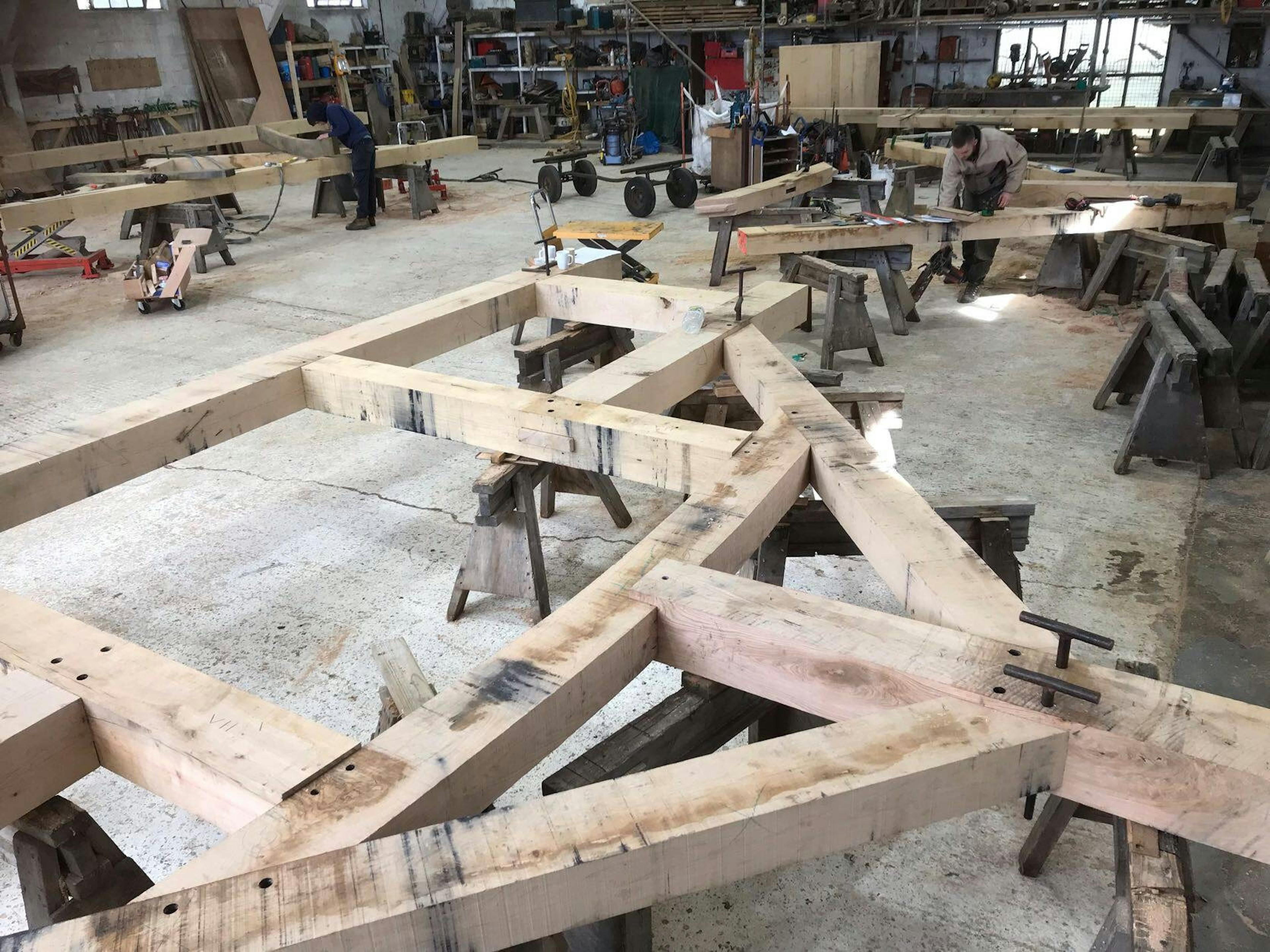 An oak frame laid out on trestle tables in a workshop