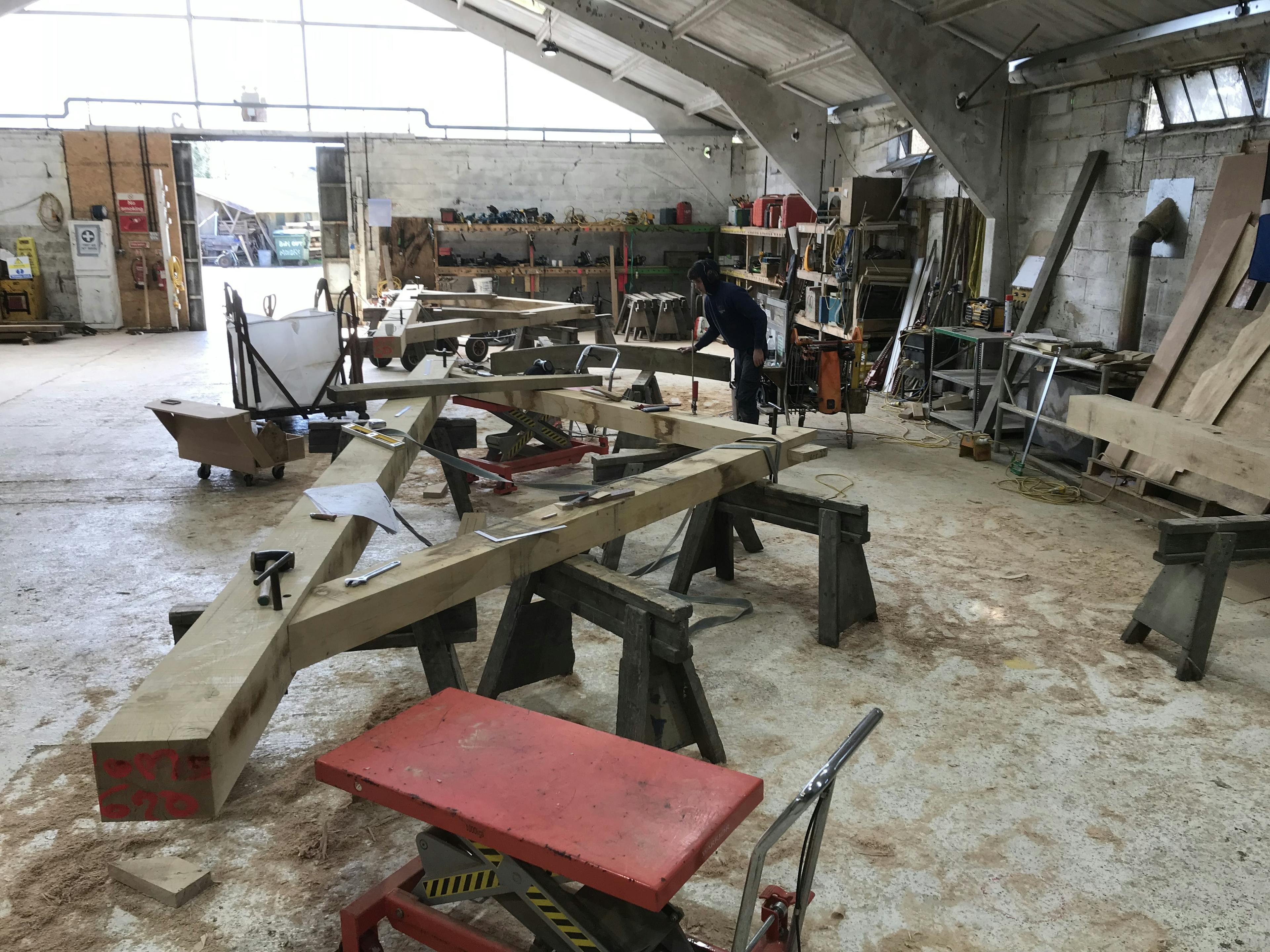 An oak frame laid out on trestle tables in a workshop