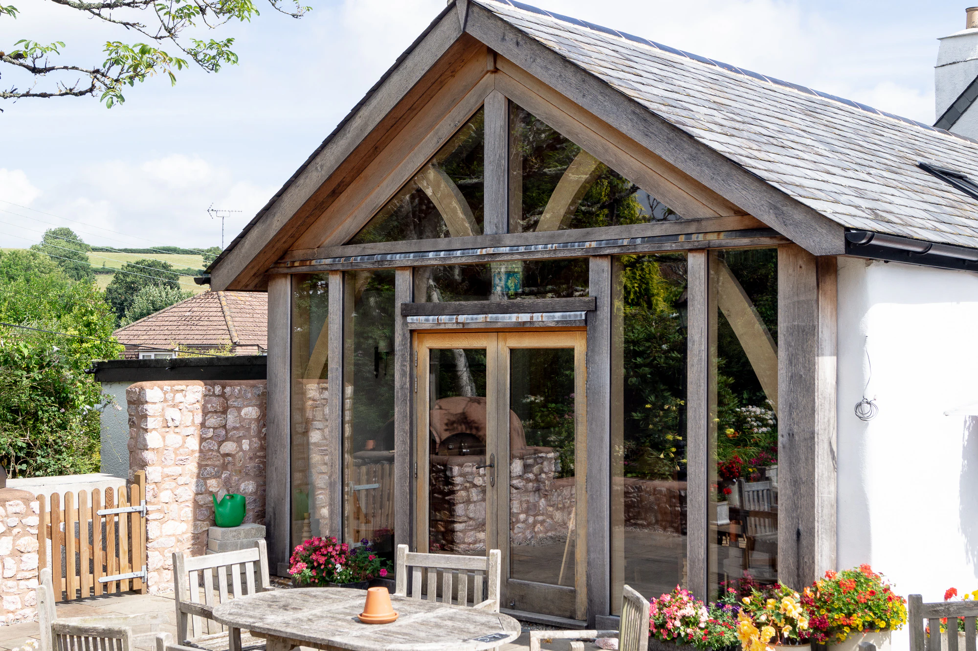 A pub garden with an oak framed extension with tables in the foreground