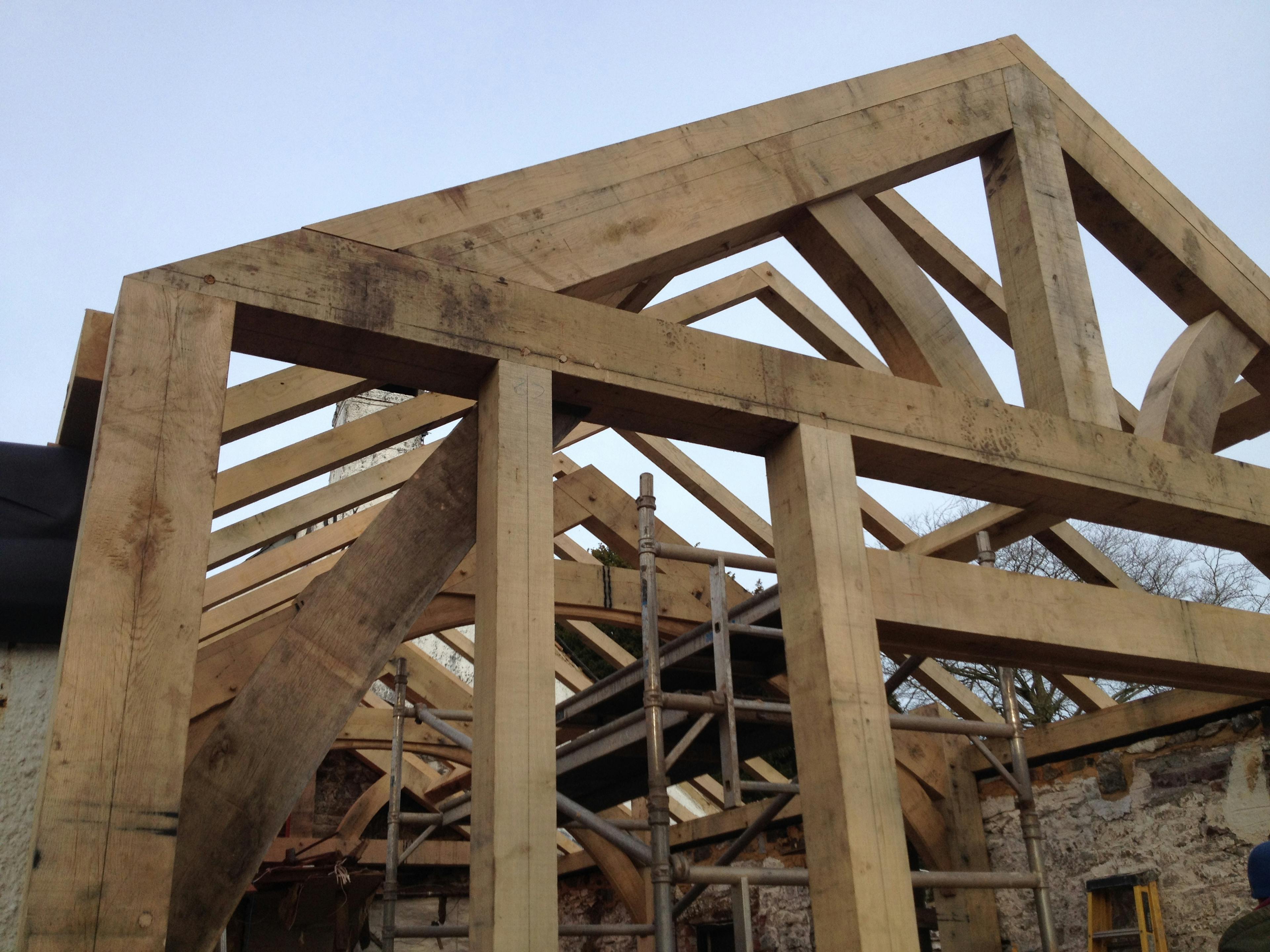 An oak framed extension to a pub being installed on a building site