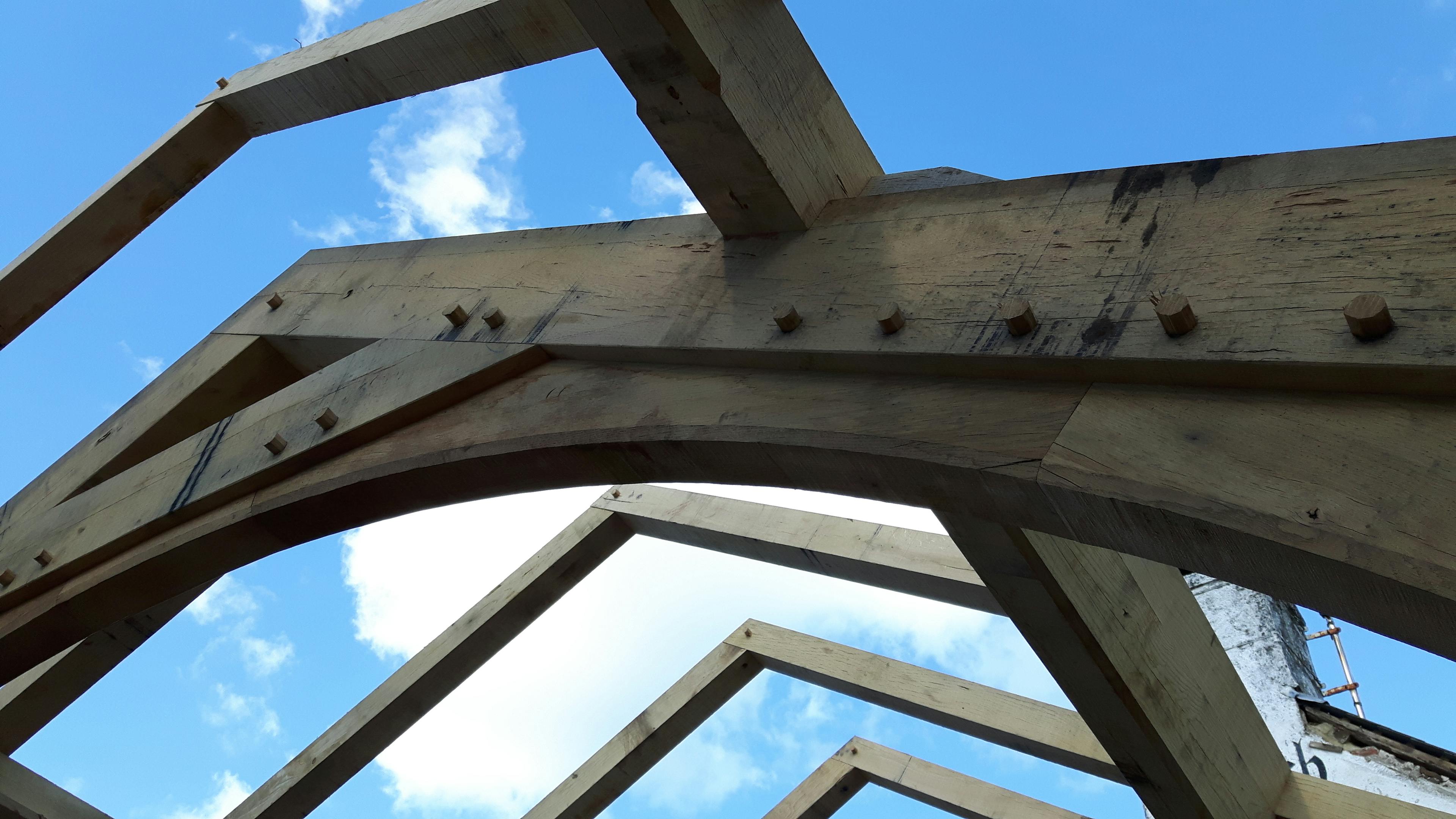 An oak framed extension to a pub being installed on a building site