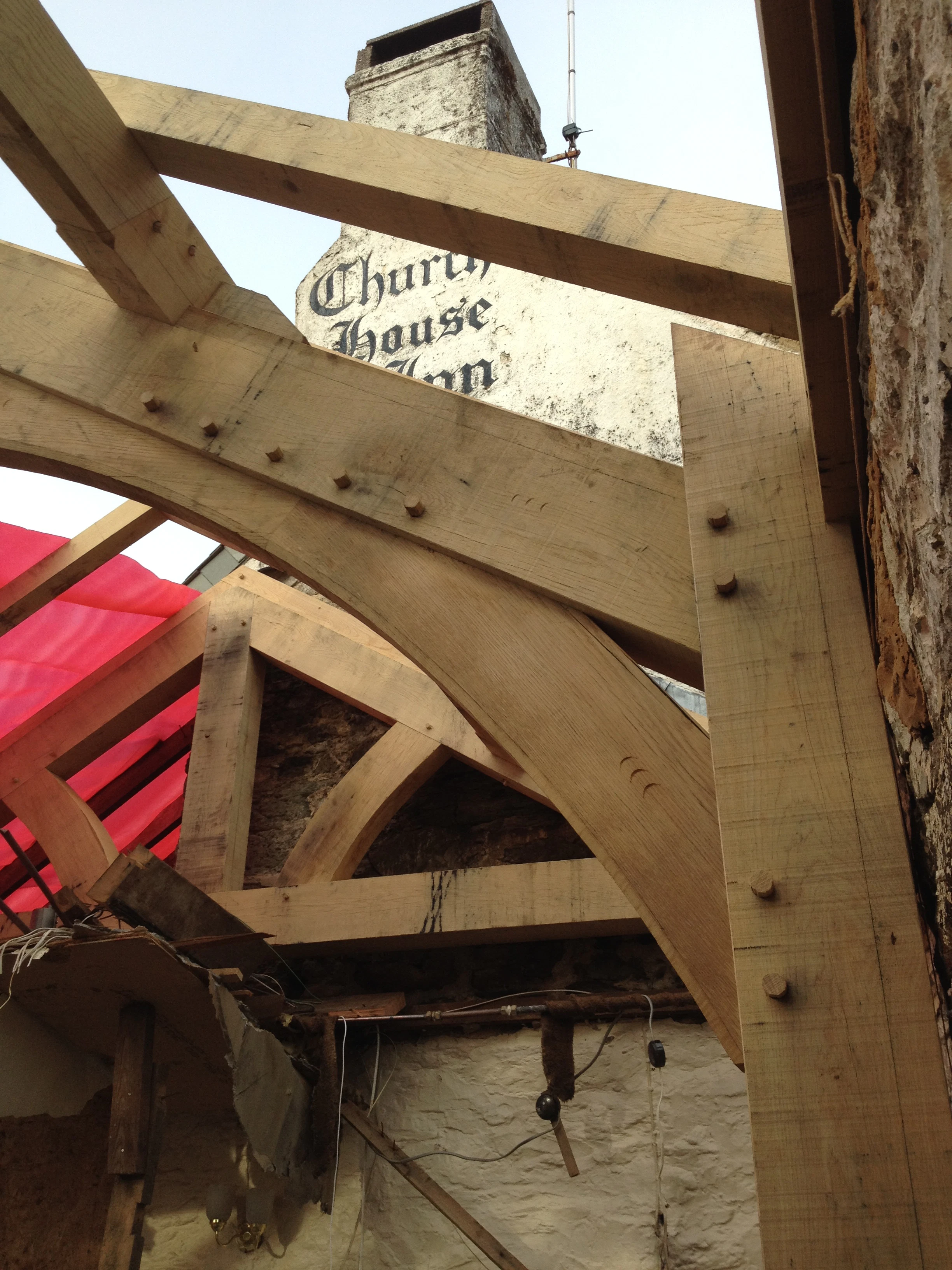 An oak framed extension to a pub being installed on a building site