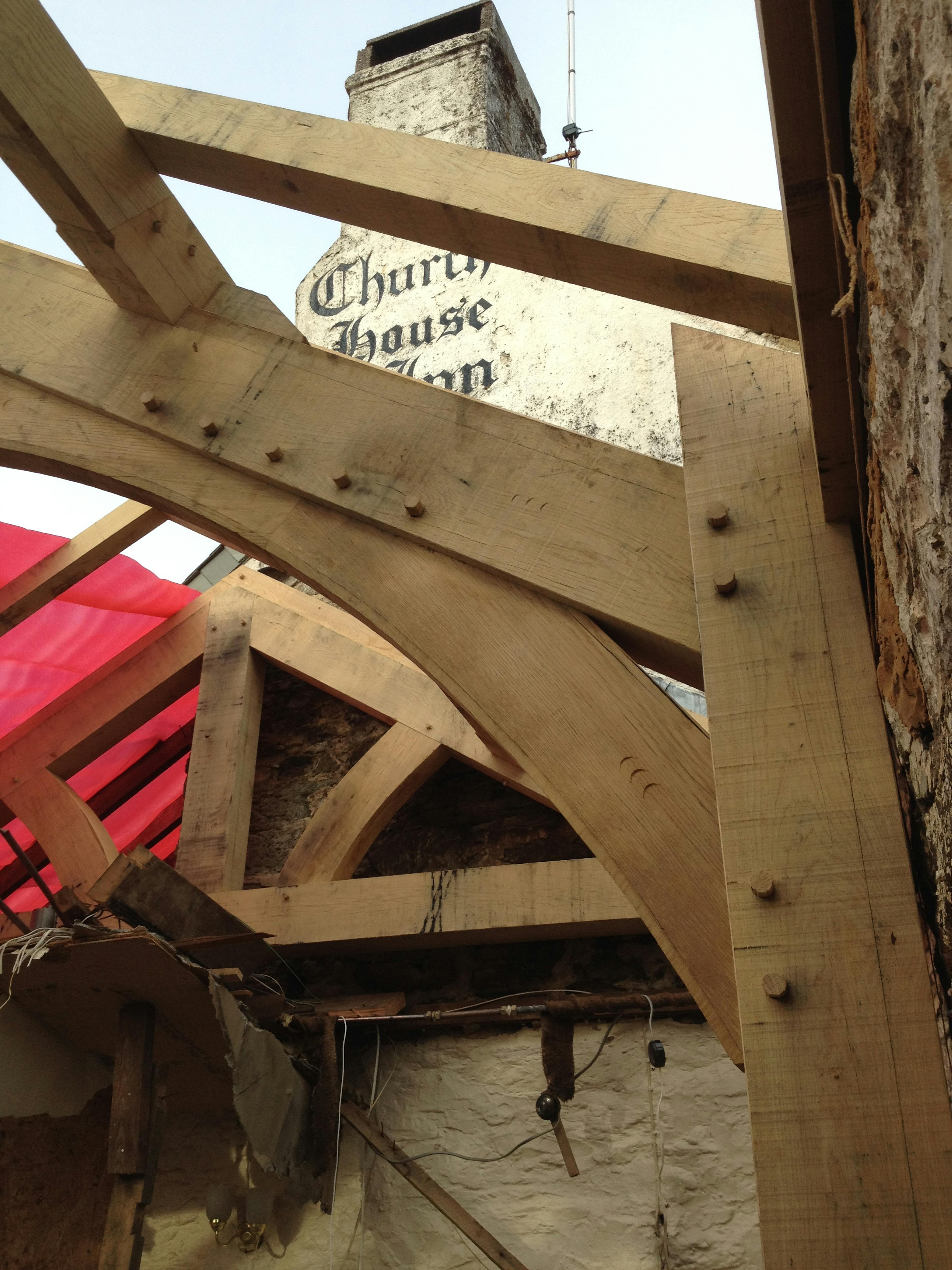 An oak framed extension to a pub being installed on a building site