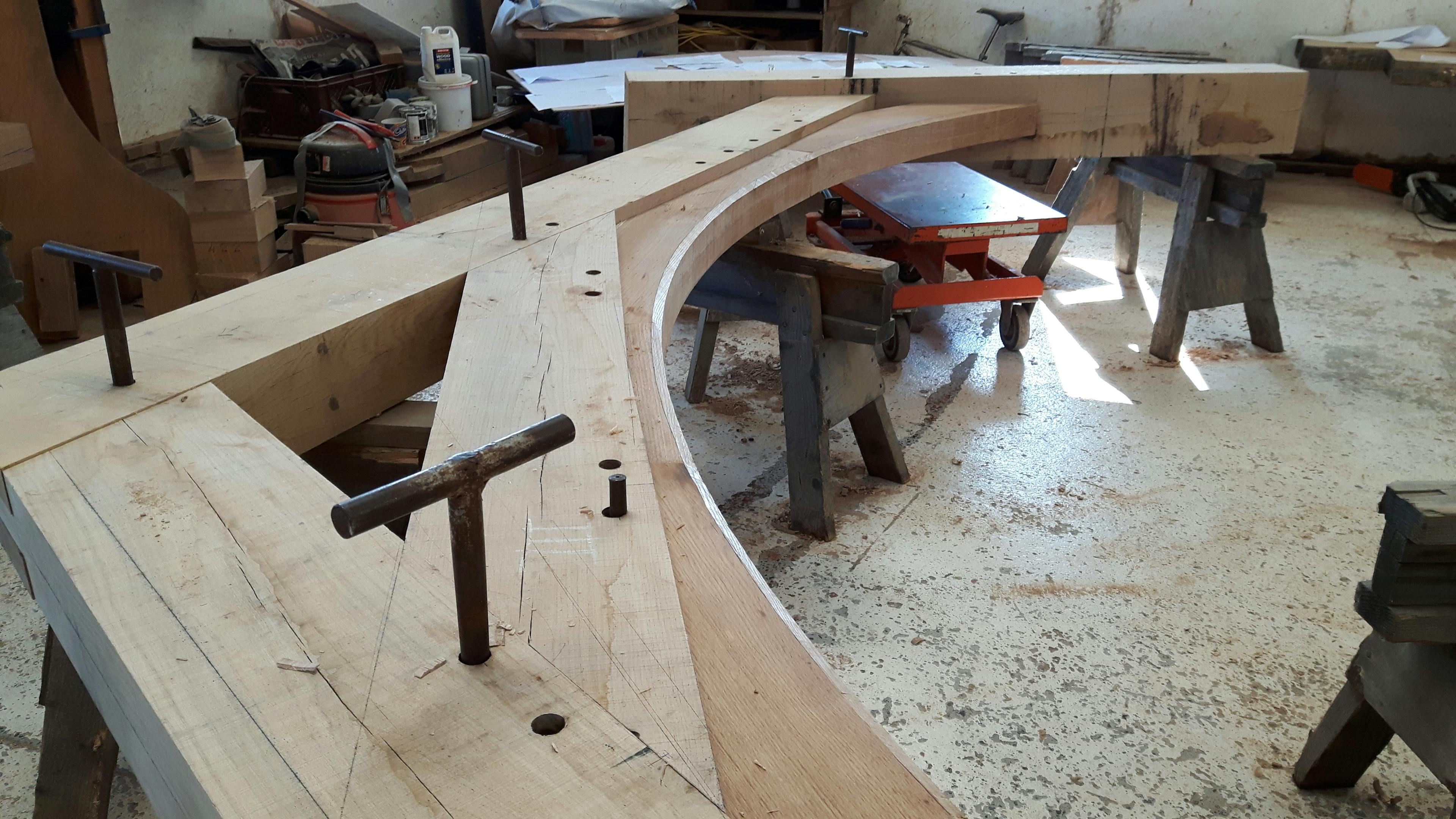 An oak frame is laid out on trestle tables in a workshop