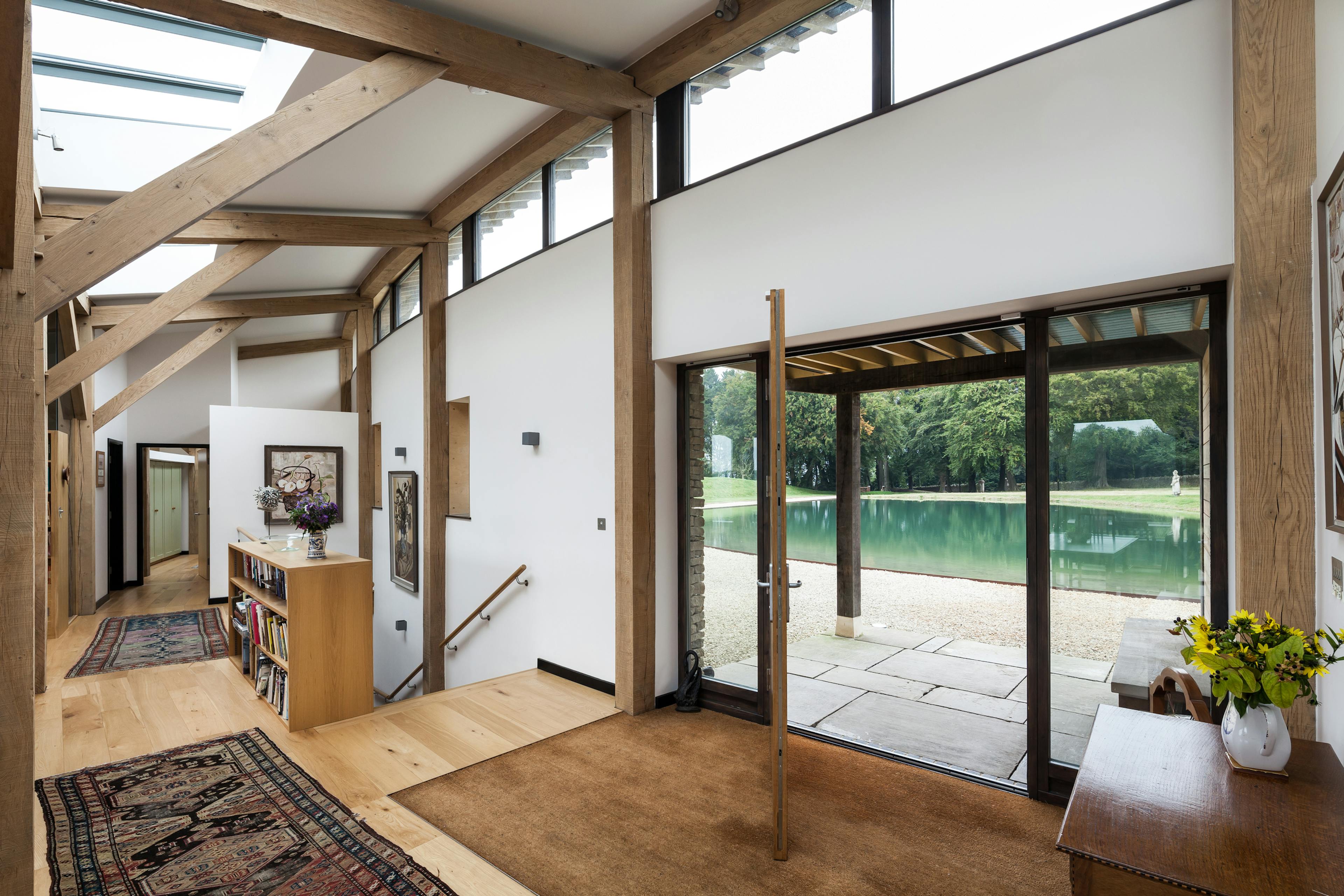 The entrance hall and stairs of a curved oak framed house with rooflights