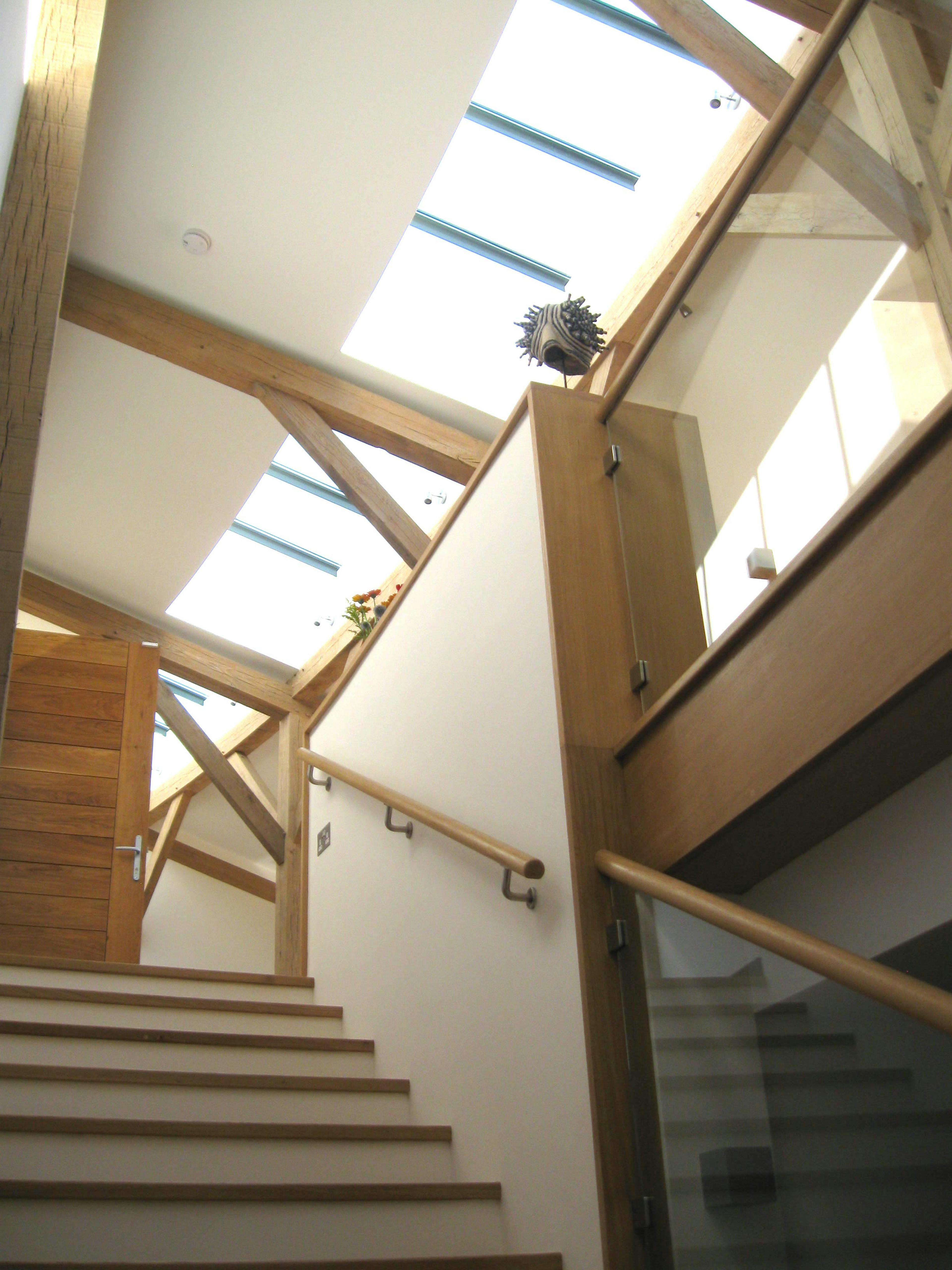 The stairs of a curved oak framed house with rooflights