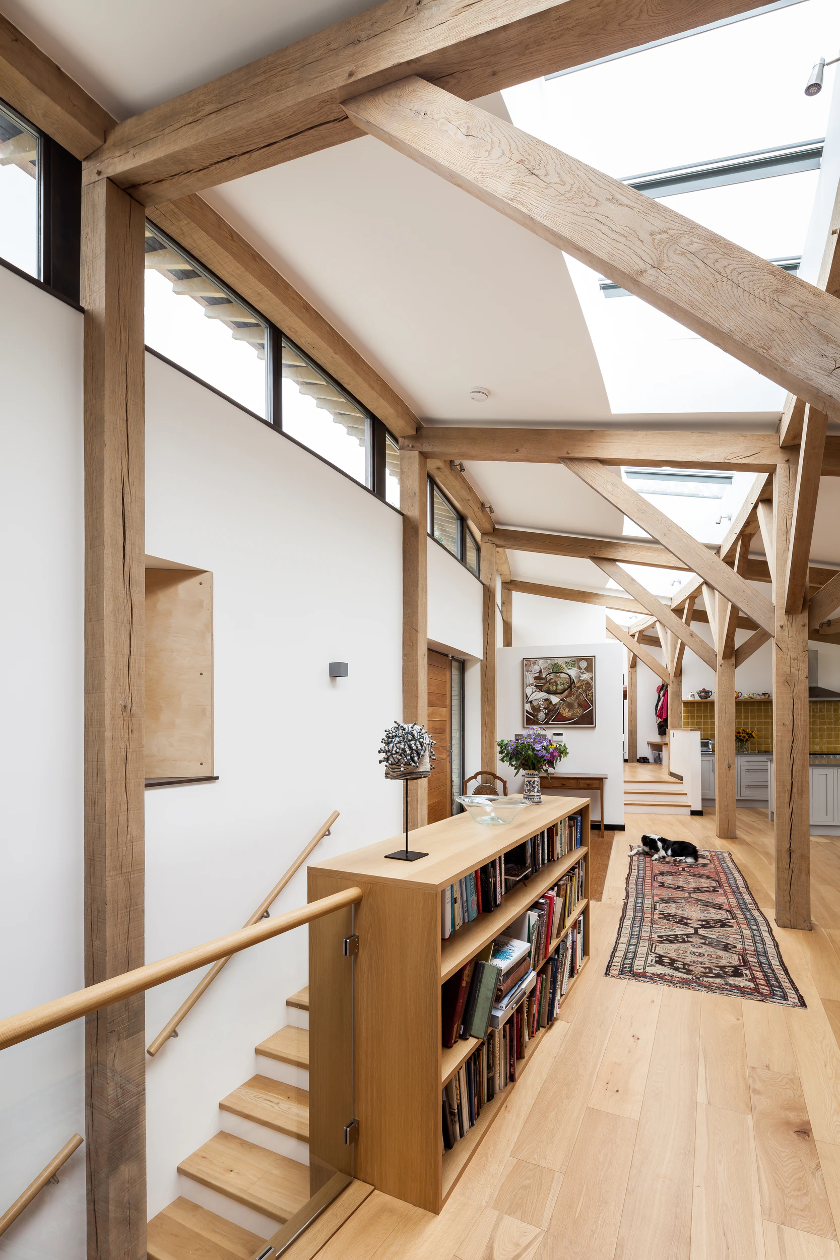 The stairs and hallway of a curved oak framed house with rooflights