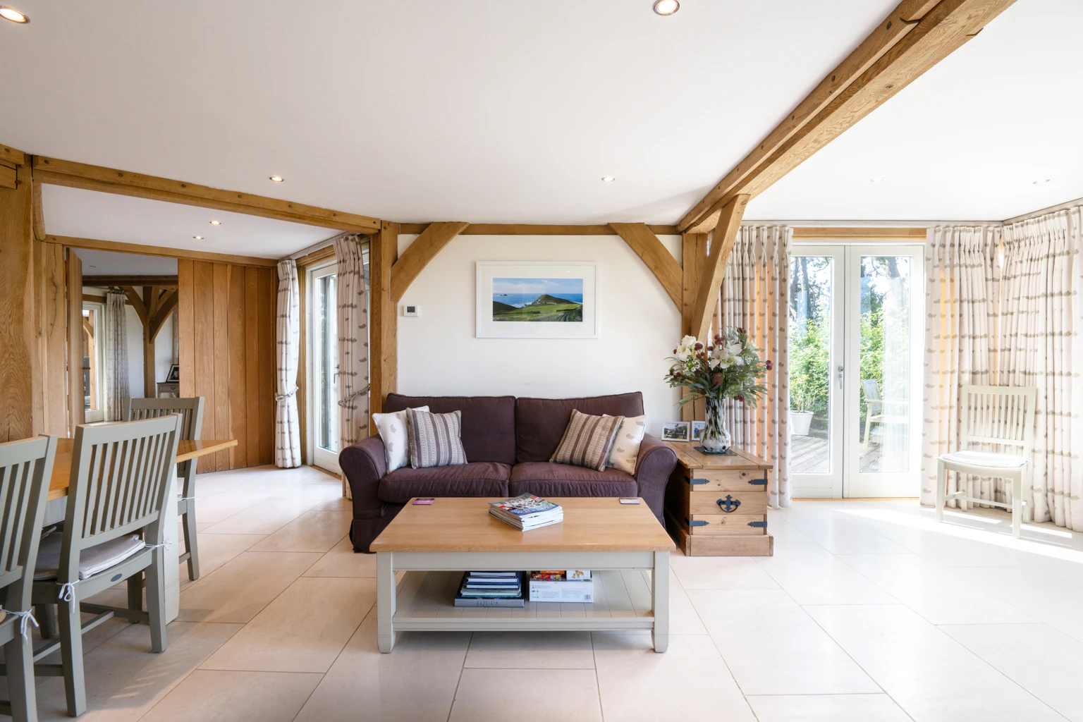 The living room of an oak framed house showing a sitting area and dining area