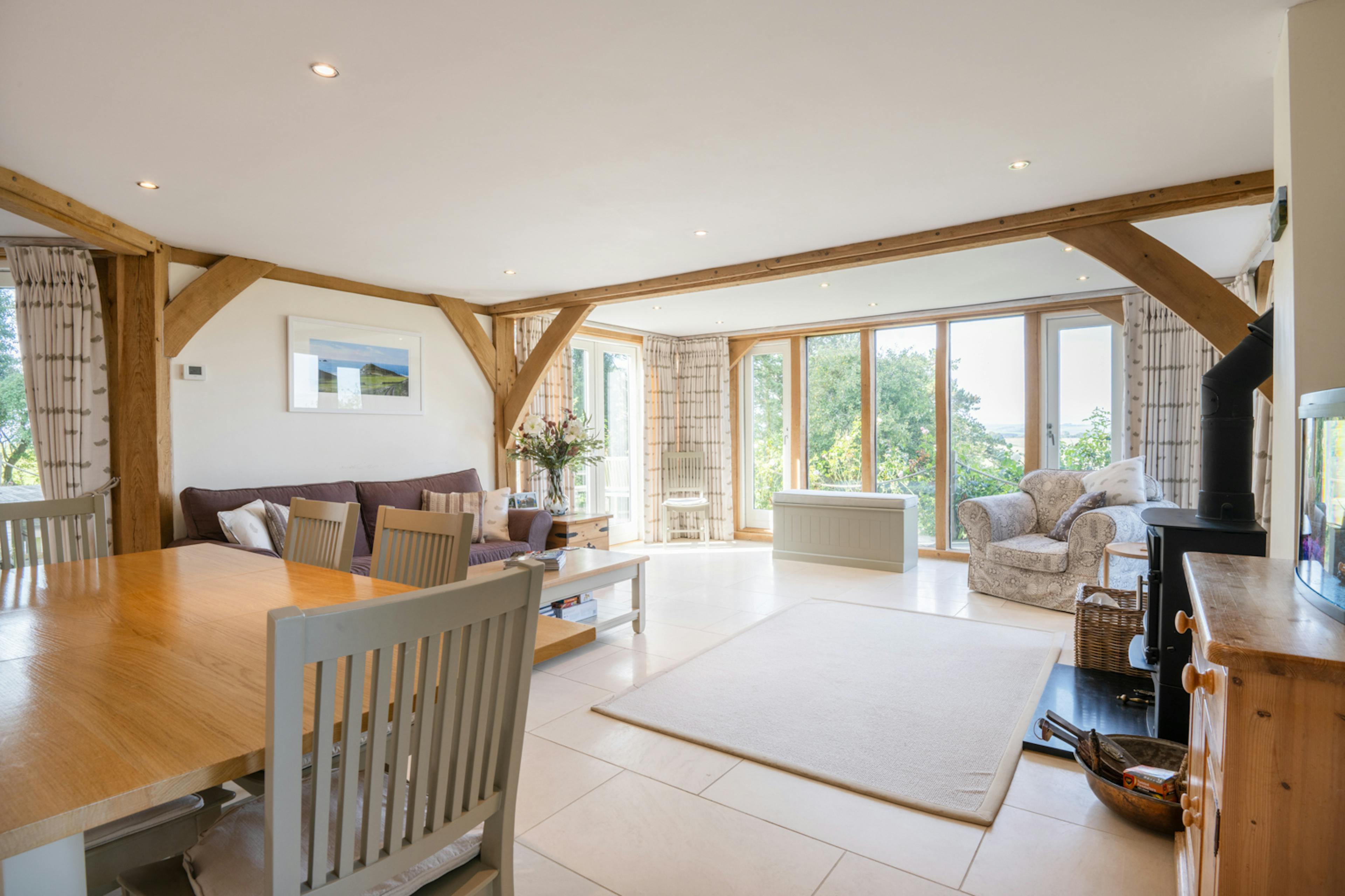 The living room of an oak framed house showing a sitting area and dining area