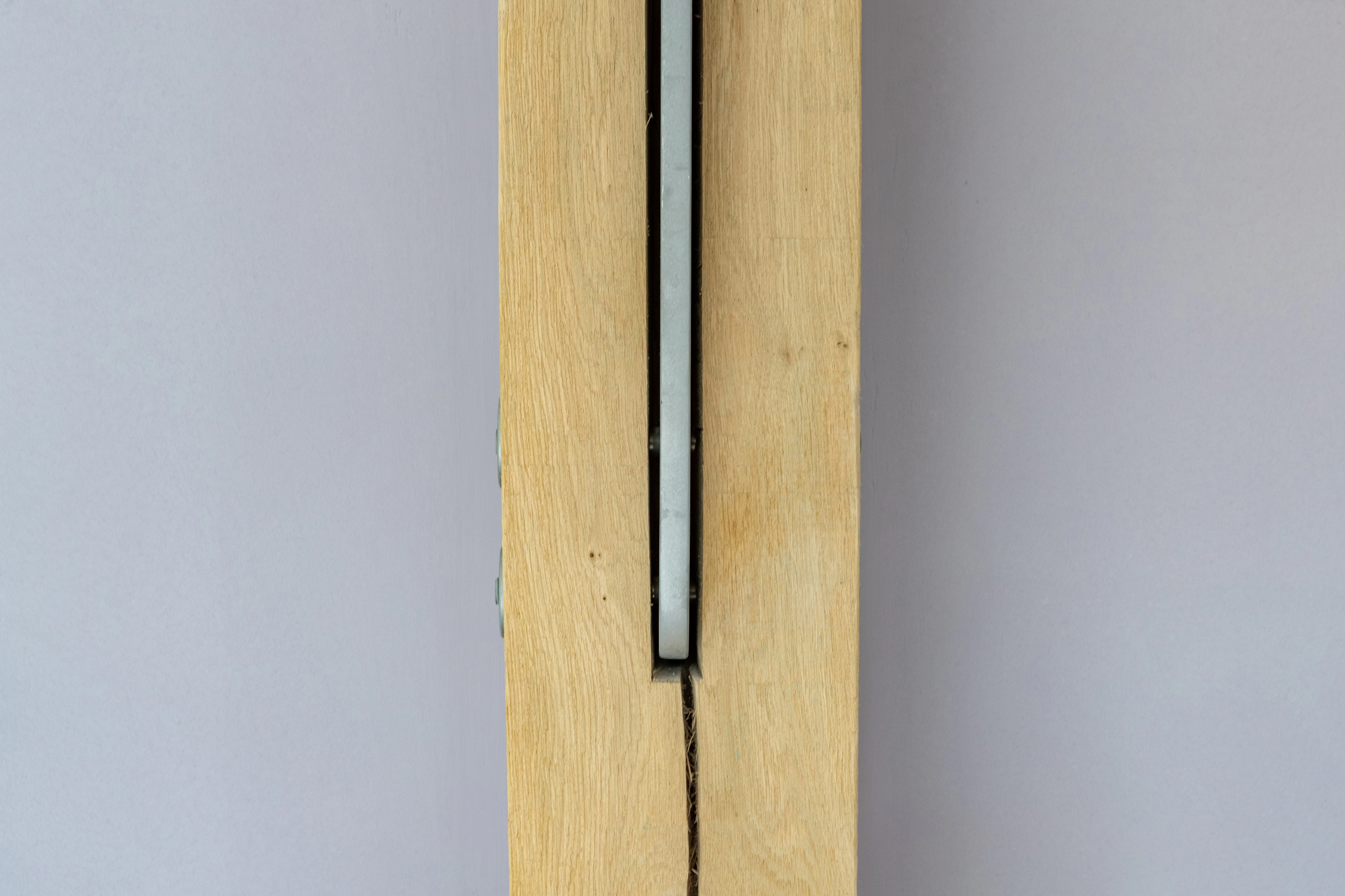 An oak frame with a steel flitch plate joint in the middle