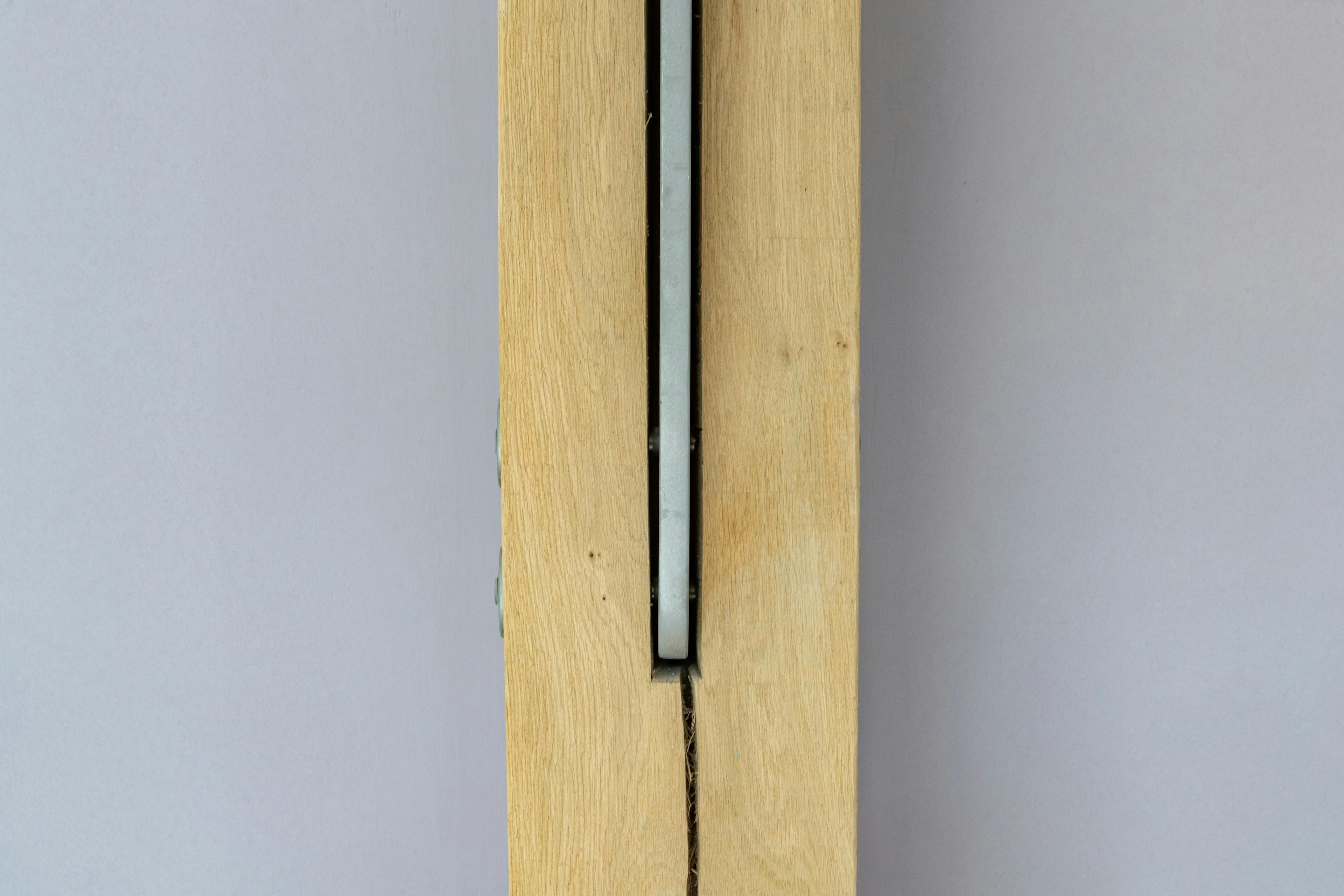 An oak frame with a steel flitch plate joint in the middle