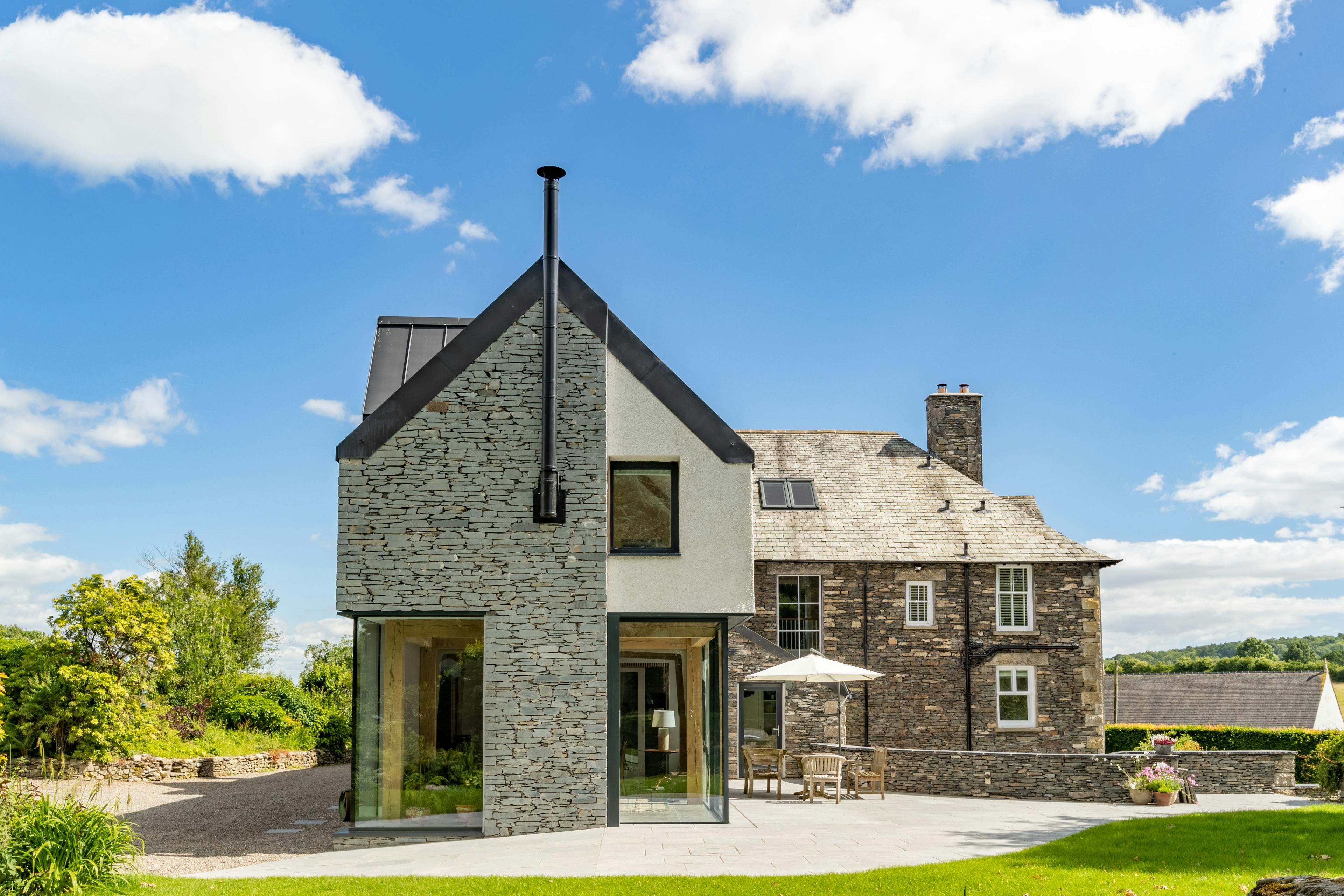 An oak frame living room extension to an Edwardian vicarage with direct access to a terrace and garden