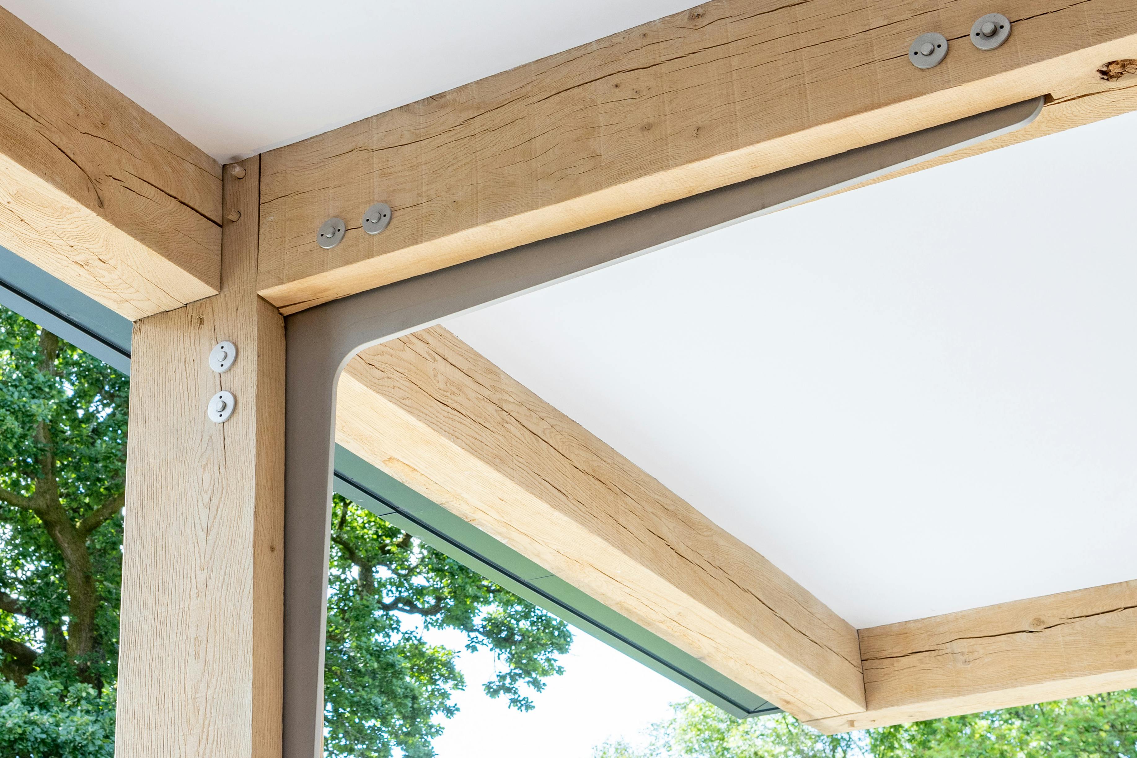 An oak frame with steel flitch plate joints in the middle and steel bolts