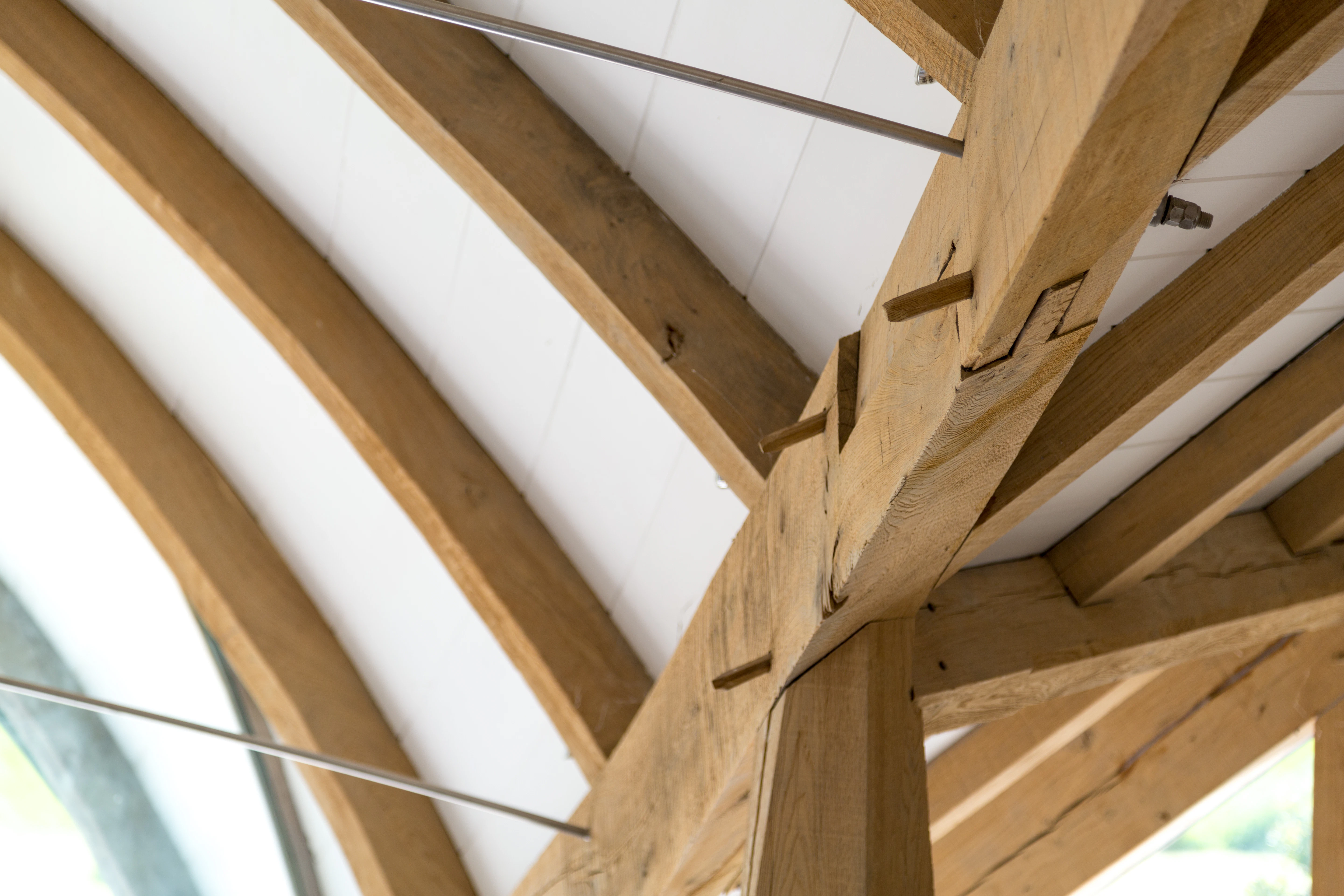 Curved oak beam featuring intricate joinery