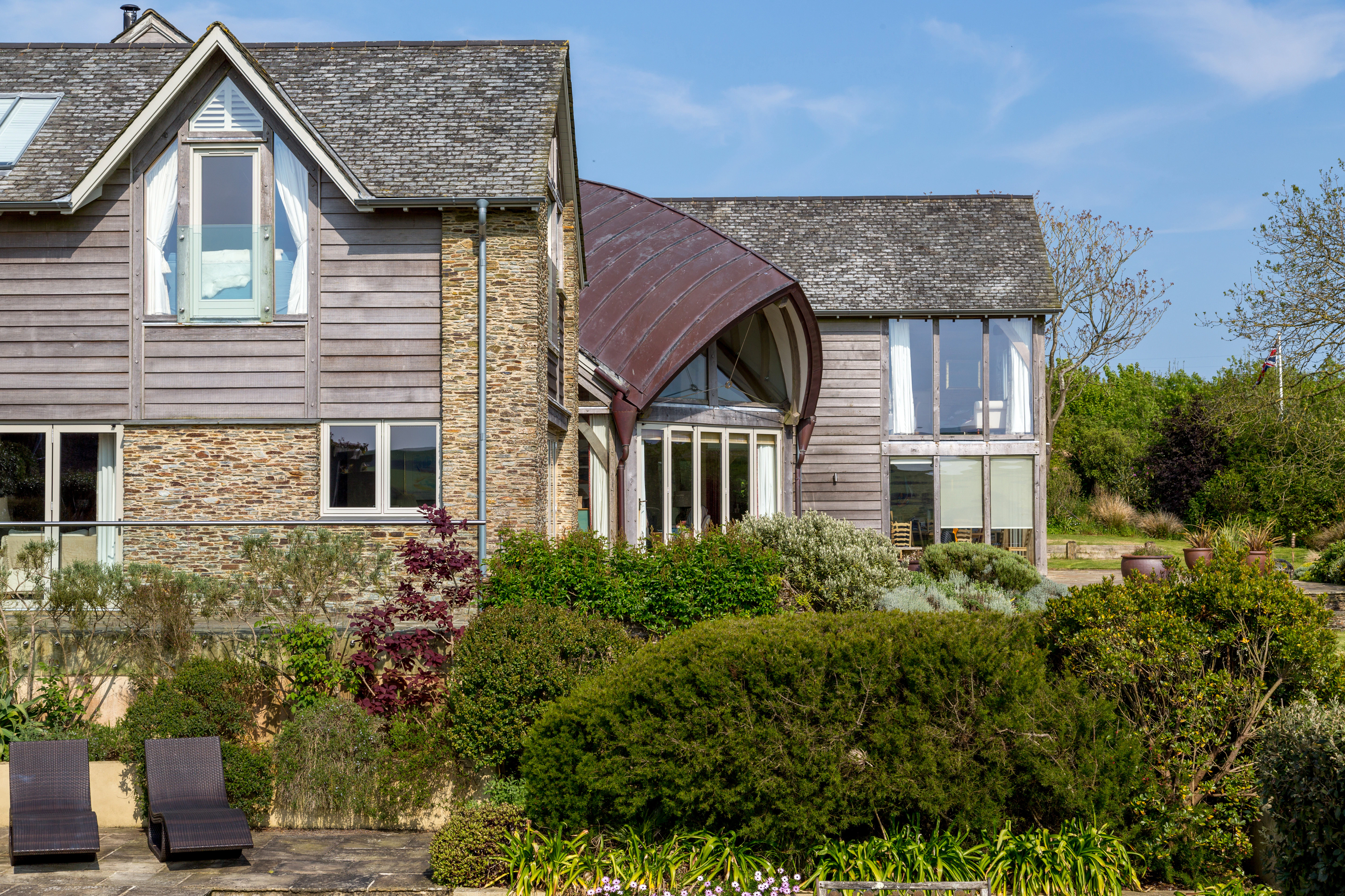 Exterior view of an oak-framed family farmhouse featuring a spacious family room beneath a stunning boat-shaped roof