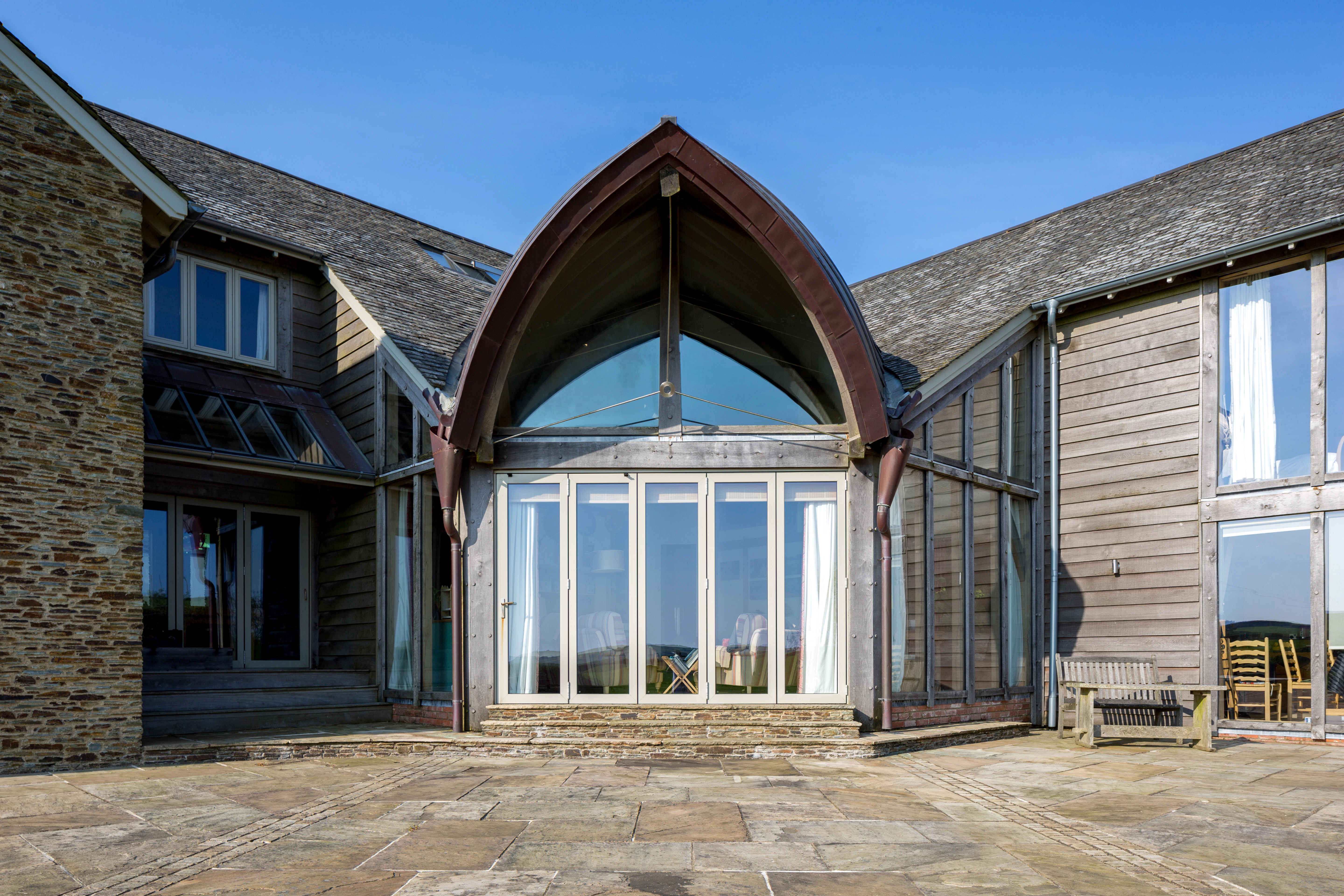Close-up exterior view of a spacious central family room beneath a stunning boat-shaped roof.