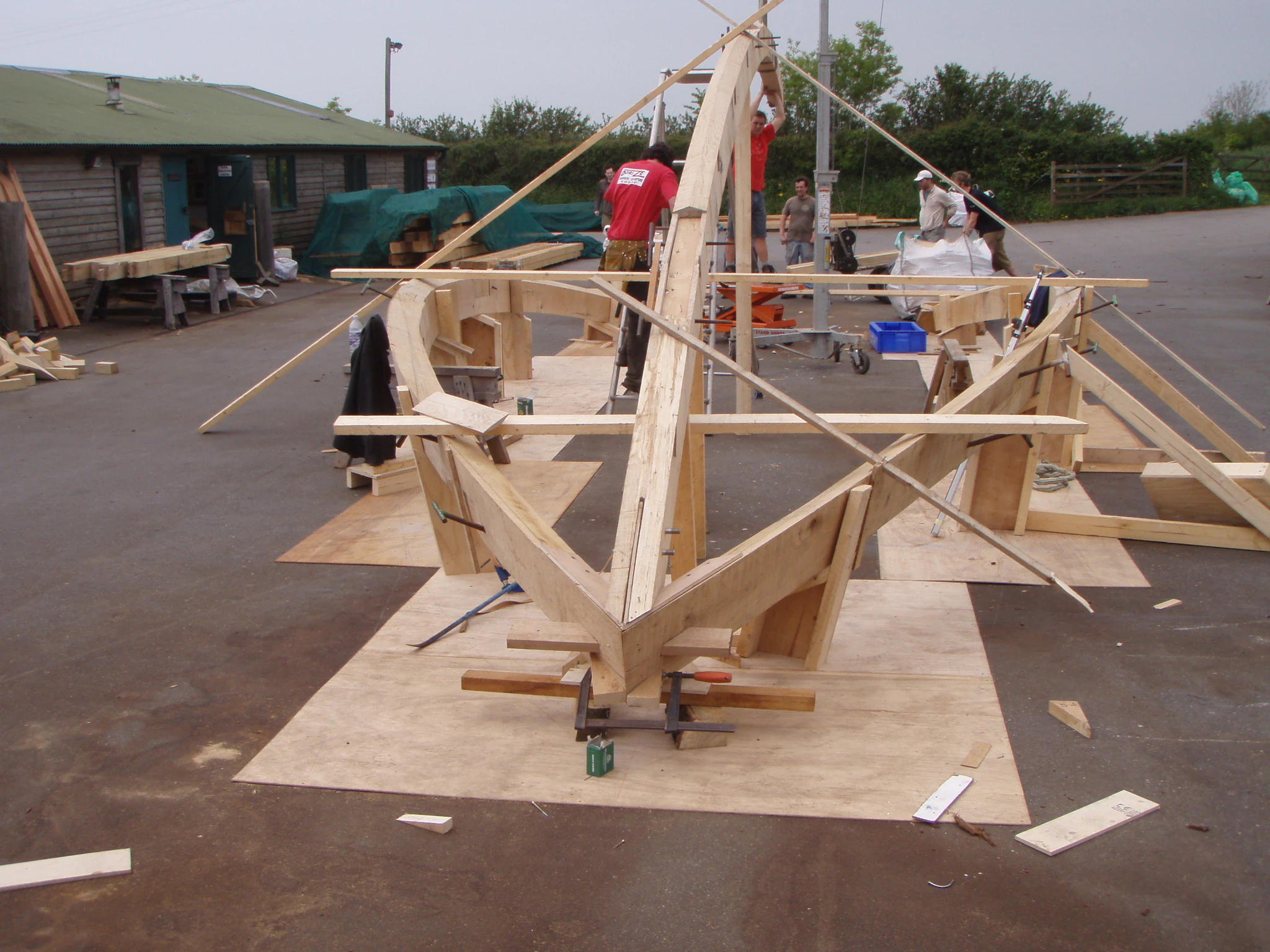 Carpenters assembling a boat roof structure in the timber framing yard