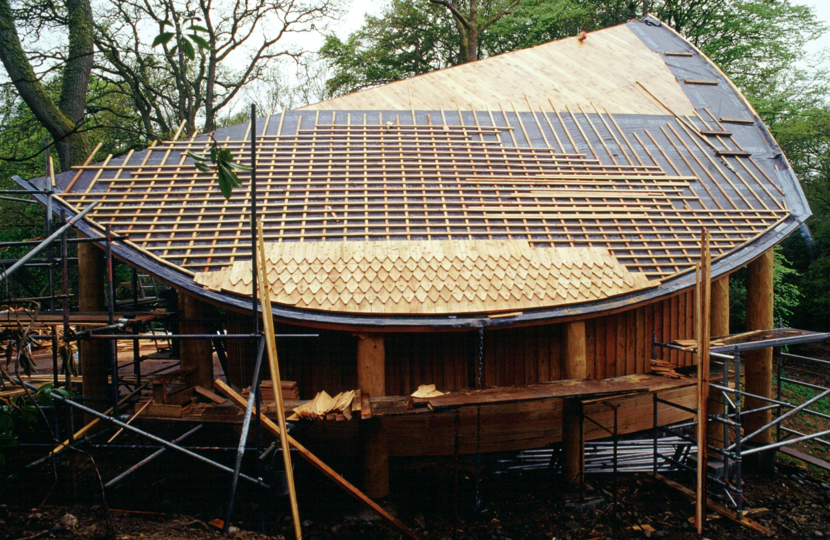 A wooden pavilion with an angled roof during construction