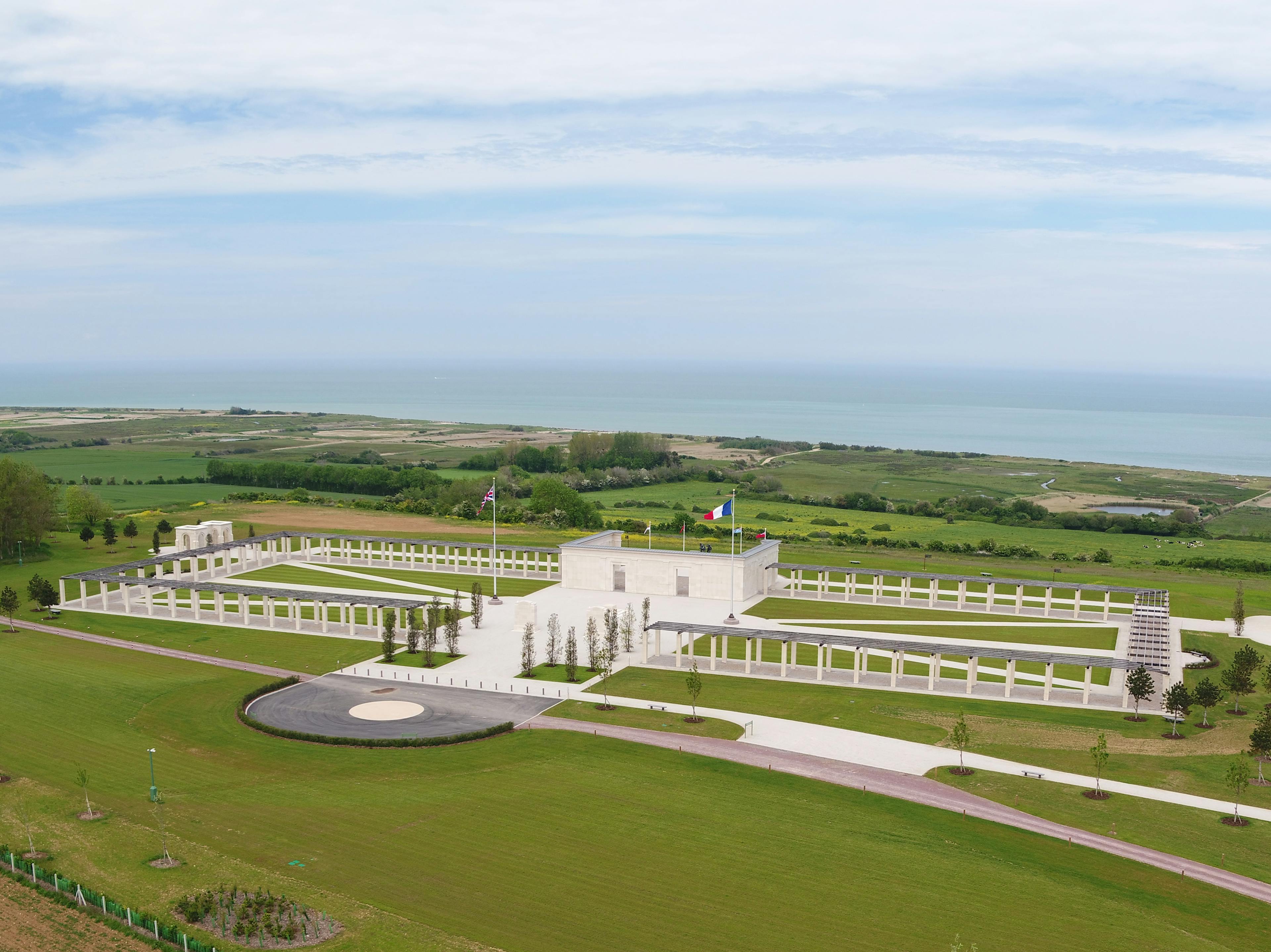 An aerial view of the British Normandy Memorial with the blue sea and sky in the background