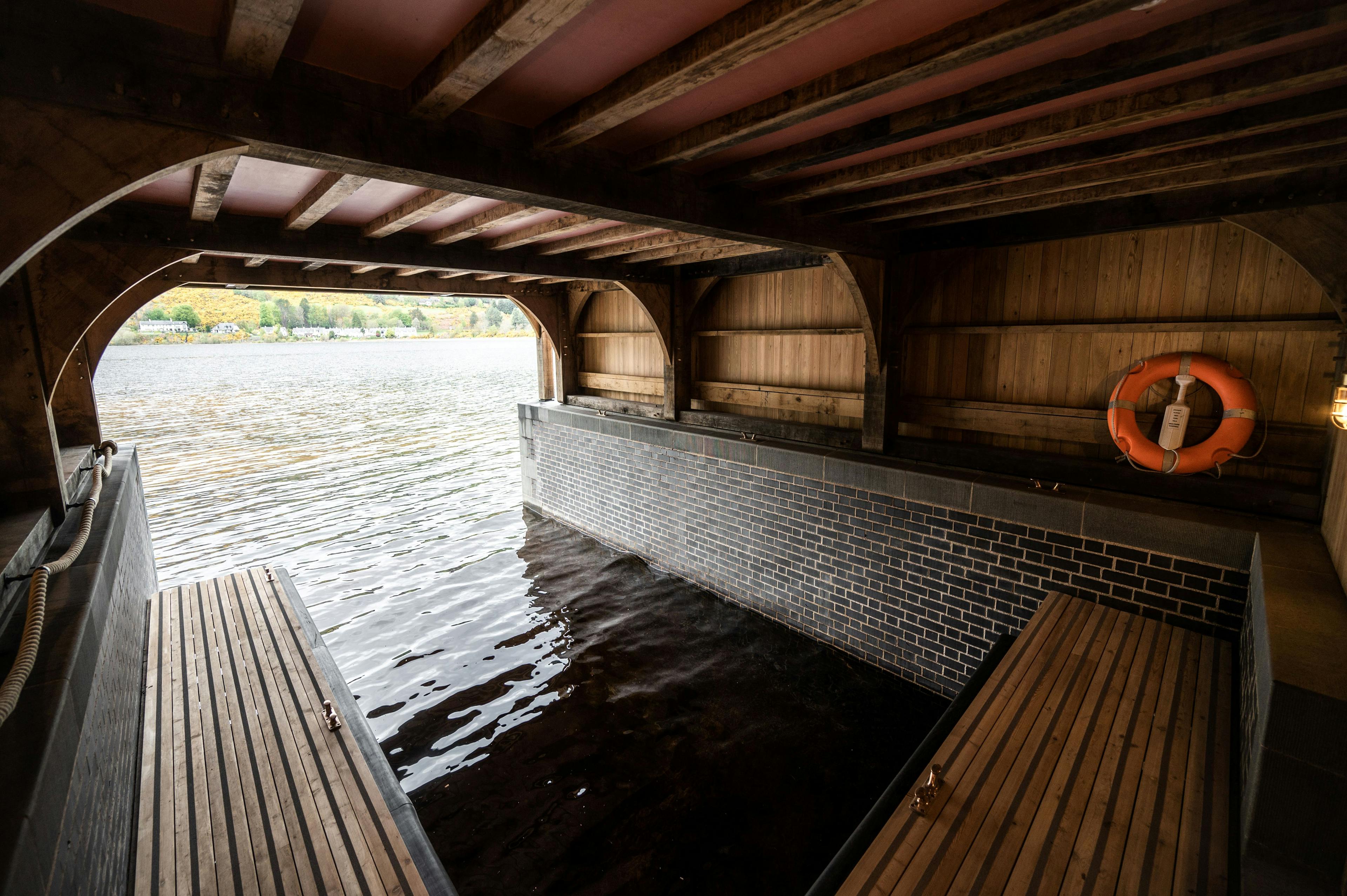 The boat storage underneath a timber framed boathouse on Loch Ness