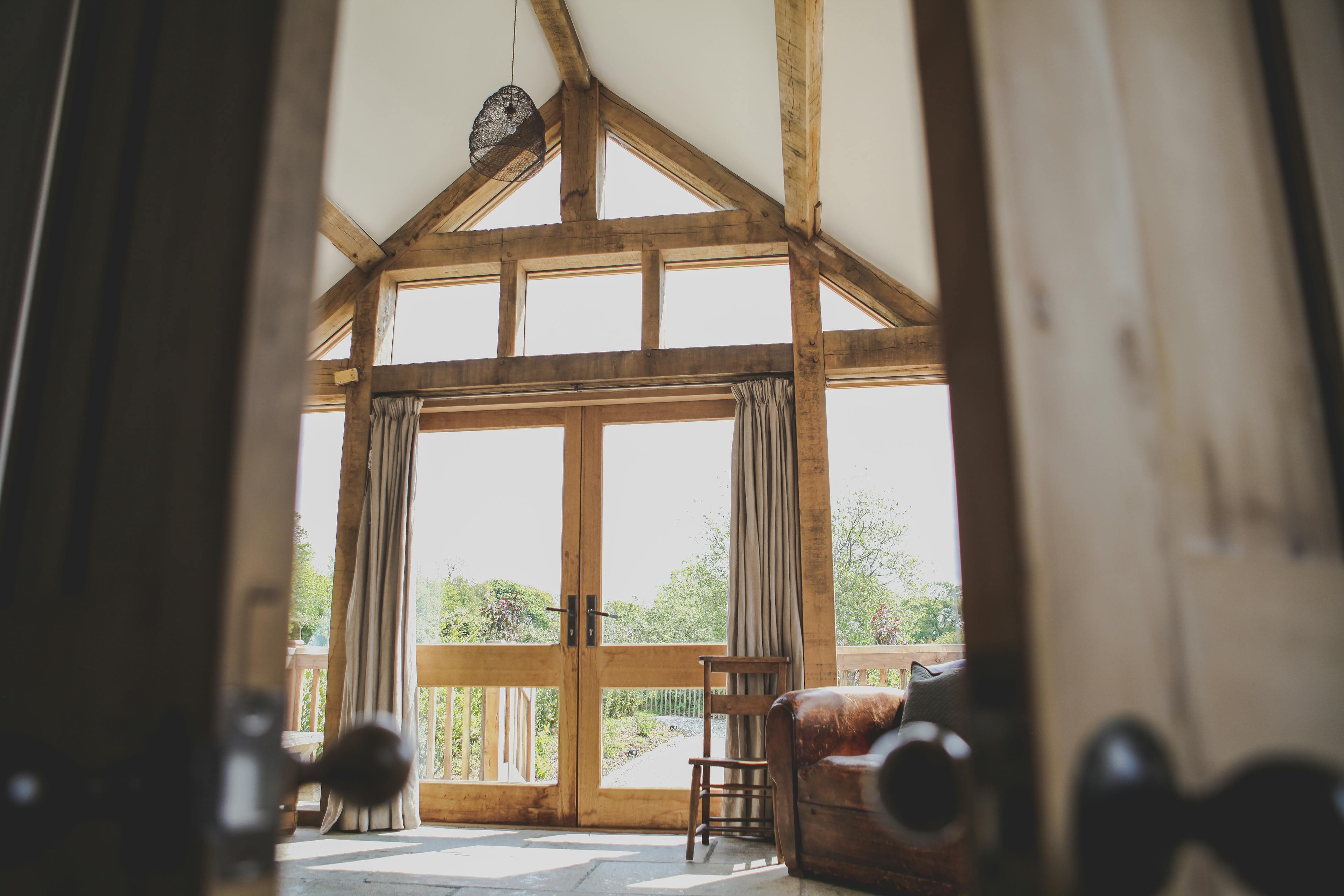 The glazed gable end from inside an oak framed cabin with a direct glazing